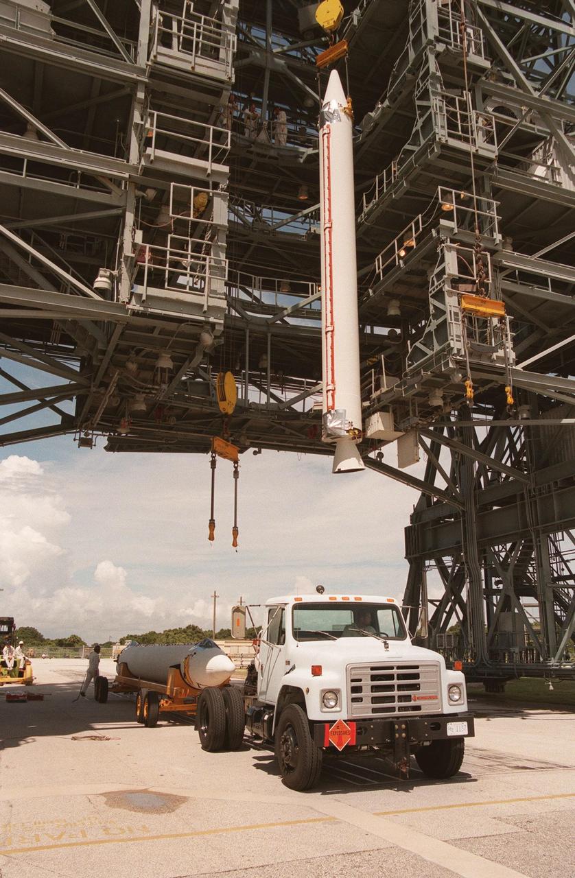 A booster is lifted off a truck for installation onto the Boeing Delta 7326 rocket that will launch Deep Space 1 at Launch Pad 17A, Cape Canaveral Air Station. Delta II rockets are medium capacity expendable launch vehicles derived from the Delta family of rockets built and launched since 1960. Since then there have been more than 245 Delta launches. The Delta 7236 has three solid rocket boosters and a Star 37 upper stage. Delta IIs are manufactured in Huntington Beach, Calif. Rocketdyne, a division of The Boeing Company, builds Delta II's main engine in Canoga Park, Calif. Deep Space 1, the first flight in NASA's New Millennium Program, is designed to validate 12 new technologies for scientific space missions of the next century. Onboard experiments include an ion propulsion engine and software that tracks celestial bodies so the spacecraft can make its own navigation decisions without the intervention of ground controllers. Deep Space 1 will complete most of its mission objectives within the first two months, but may also do a flyby of a near-Earth asteroid, 1992 KD, in July 1999