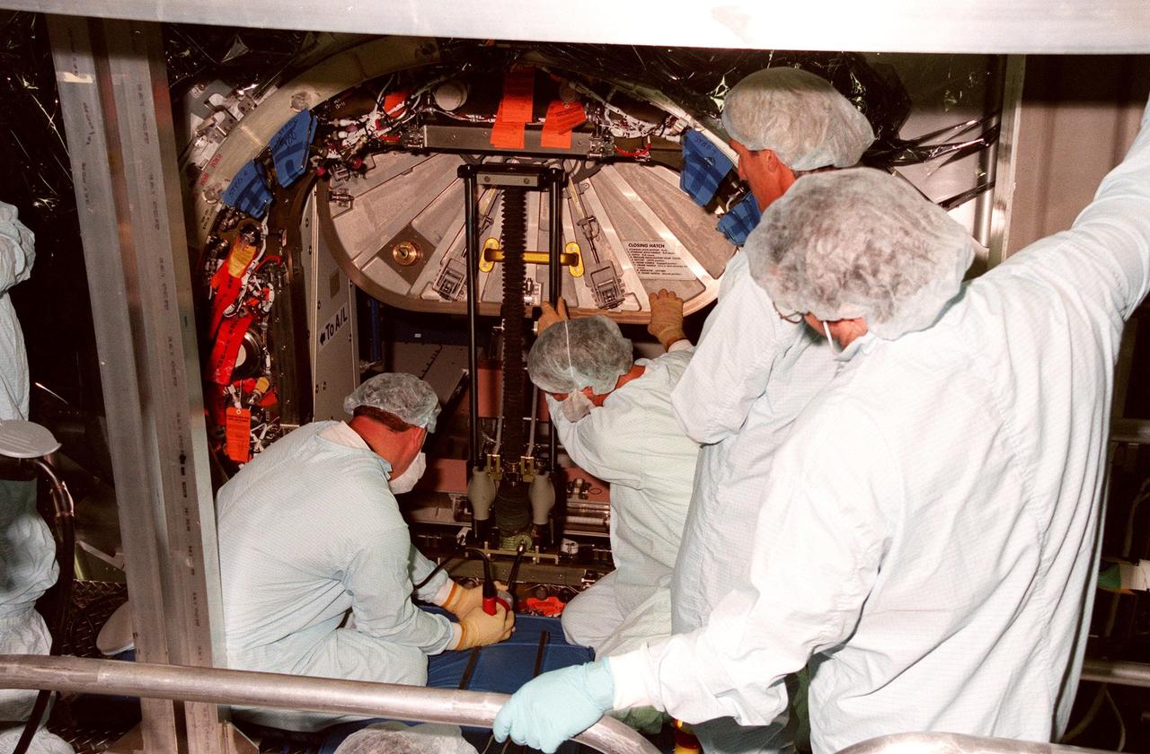 KENNEDY SPACE CENTER, FLA. -- Workers in the Space Station Processing Facility prepare to close the access hatch to the Unity connecting module, part of the International Space Station, in preparation for its launch aboard Space Shuttle Endeavour on STS-88 in December. Unity will now undergo a series of leak checks before a final purge of clean, dry air inside the module to ready it for initial operations in space. Other testing includes the common berthing mechanism to which other space station elements will dock and the Pad Demonstration Test to verify the compatibility of the module with the Space Shuttle as well as the ability of the astronauts to send and receive commands to Unity from the flight deck of the orbiter. The next time the hatch will be opened it will be by astronauts on orbit. Unity is expected to be ready for installation into the payload canister on Oct. 25, and transported to Launch Pad 39-A on Oct. 27. The Unity will be mated to the Russian-built Zarya control module which should already be in orbit at that time