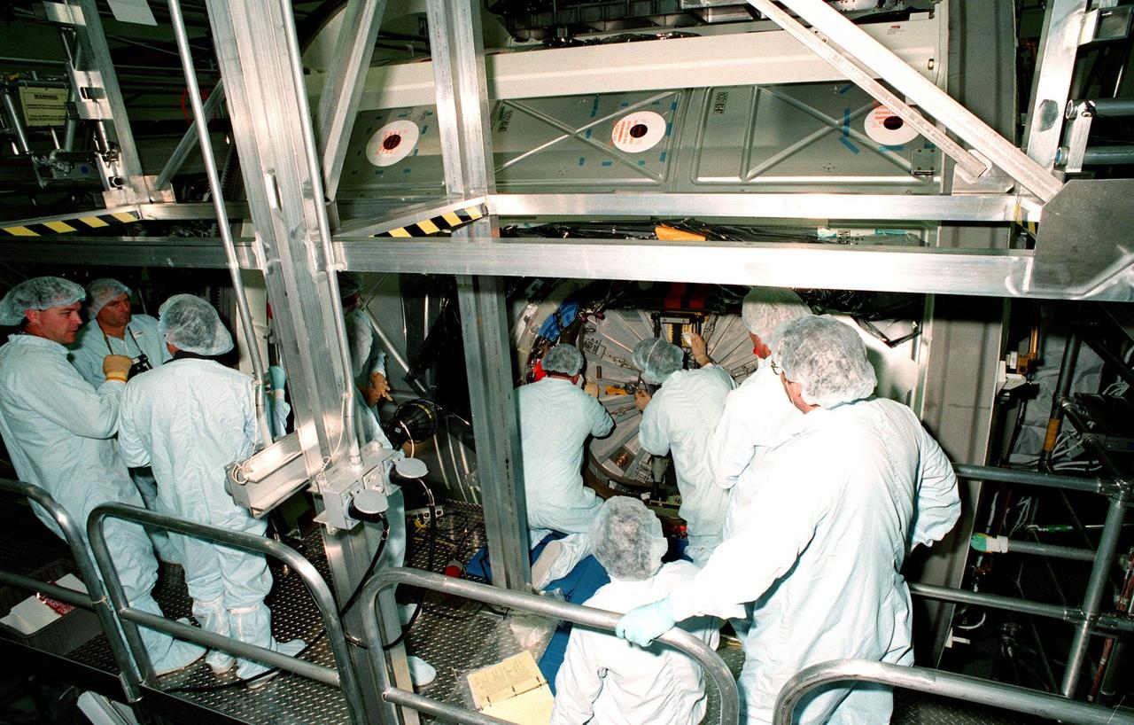 KENNEDY SPACE CENTER, FLA. -- Workers in the Space Station Processing Facility close the access hatch to the Unity connecting module, part of the International Space Station, before its launch aboard Space Shuttle Endeavour on STS-88 in December. Unity will now undergo a series of leak checks before a final purge of clean, dry air inside the module to ready it for initial operations in space. Other testing includes the common berthing mechanism to which other space station elements will dock and the Pad Demonstration Test to verify the compatibility of the module with the Space Shuttle as well as the ability of the astronauts to send and receive commands to Unity from the flight deck of the orbiter. The next time the hatch will be opened it will be by astronauts on orbit. Unity is expected to be ready for installation into the payload canister on Oct. 25, and transported to Launch Pad 39-A on Oct. 27. The Unity will be mated to the Russian-built Zarya control module which should already be in orbit at that time