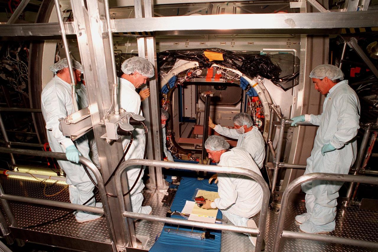 KENNEDY SPACE CENTER, FLA. -- Workers in the Space Station Processing Facility make final preparations for closing the access hatch to the Unity connecting module, part of the International Space Station, before its launch aboard Space Shuttle Endeavour on STS-88 in December. Unity will now undergo a series of leak checks before a final purge of clean, dry air inside the module to ready it for initial operations in space. Other testing includes the common berthing mechanism to which other space station elements will dock and the Pad Demonstration Test to verify the compatibility of the module with the Space Shuttle as well as the ability of the astronauts to send and receive commands to Unity from the flight deck of the orbiter. The next time the hatch will be opened it will be by astronauts on orbit. Unity is expected to be ready for installation into the payload canister on Oct. 25, and transported to Launch Pad 39-A on Oct. 27. The Unity will be mated to the Russian-built Zarya control module which should already be in orbit at that time