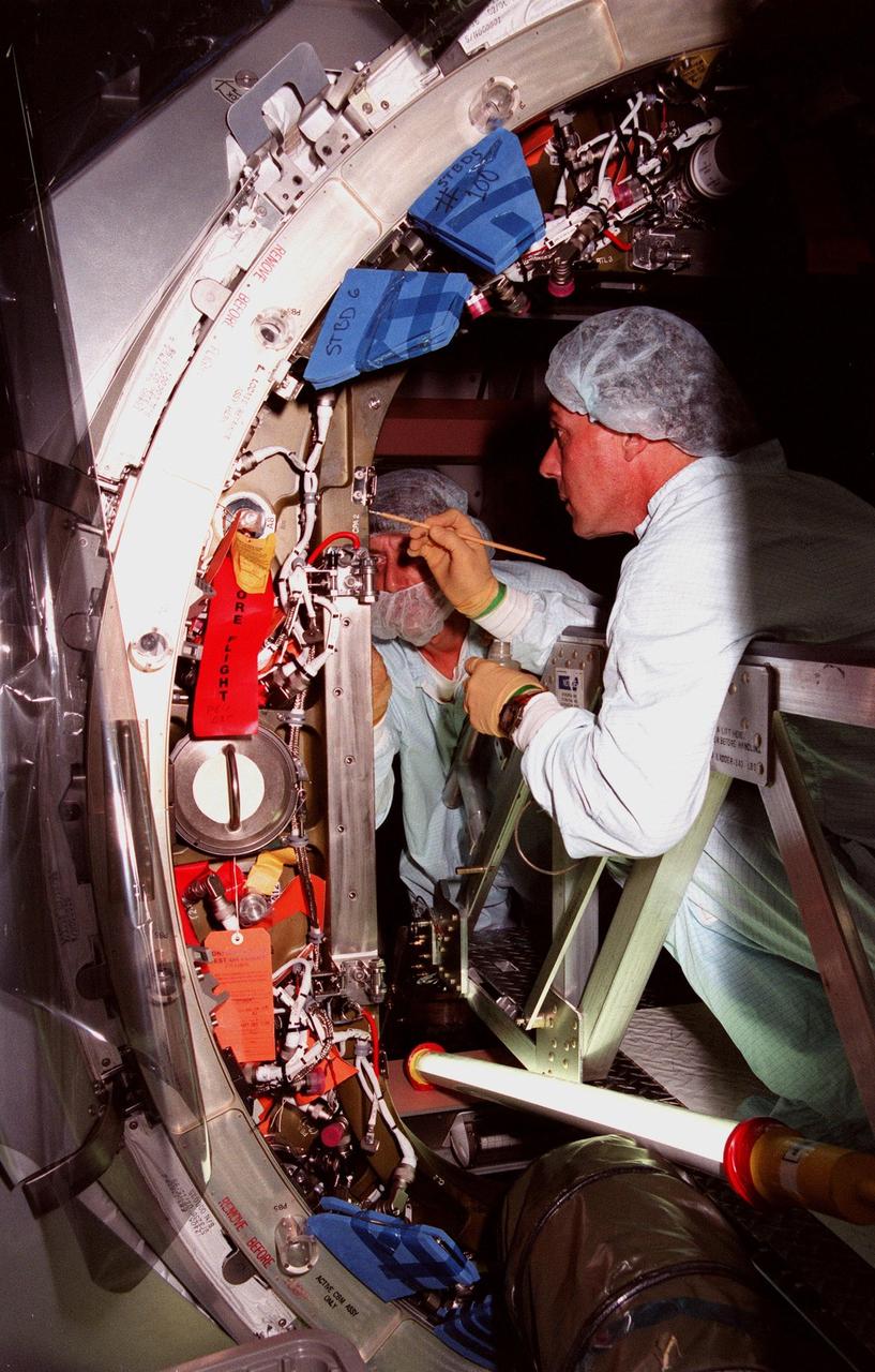 KENNEDY SPACE CENTER, FLA. -- Workers in the Space Station Processing Facility prepare the hatch of the Unity connecting module for closure before its launch aboard Space Shuttle Endeavour on STS-88 in December. Unity will now undergo a series of leak checks before a final purge of clean, dry air inside the module to ready it for initial operations in space. Other testing includes the common berthing mechanism to which other space station elements will dock and the Pad Demonstration Test to verify the compatibility of the module with the Space Shuttle as well as the ability of the astronauts to send and receive commands to Unity from the flight deck of the orbiter. The next time the hatch will be opened it will be by astronauts on orbit. Unity is expected to be ready for installation into the payload canister on Oct. 25, and transported to Launch Pad 39-A on Oct. 27. The Unity will be mated to the Russian-built Zarya control module which should already be in orbit at that time