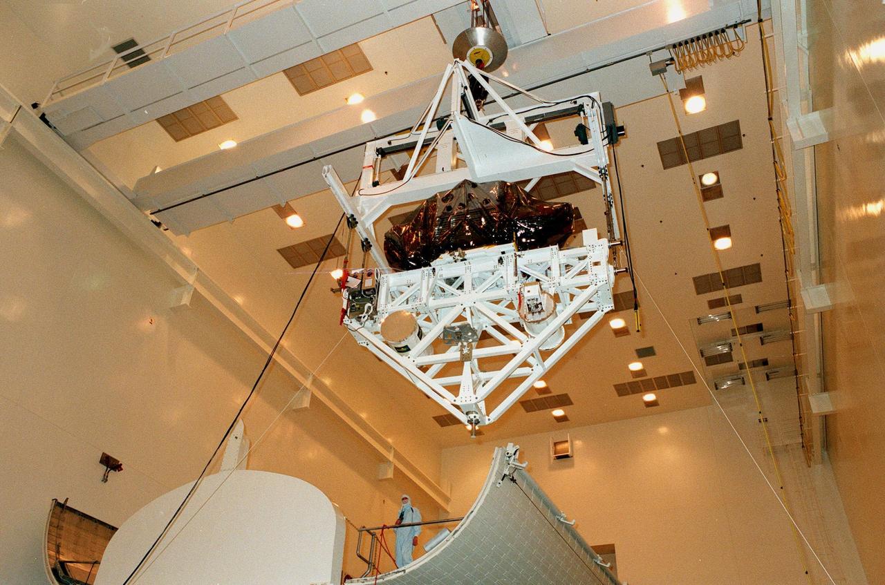 KENNEDY SPACE CENTER, FLA. -- The Spartan solar-observing deployable spacecraft is suspended above the payload canister in the Multi-Payload Processing Facility at KSC. Spartan is one of the payloads for the STS-95 mission, scheduled to launch Oct. 29. Spartan is a solar physics spacecraft designed to perform remote sensing of the hot outer layers of the sun's atmosphere or corona. The objective of the observations is to investigate the mechanisms causing the heating of the solar corona and the acceleration of the solar wind which originates in the corona. Other research payloads include the Hubble Space Telescope Orbital Systems Test Platform, the International Extreme Ultraviolet Hitchhiker, and the SPACEHAB single module with experiments on space flight and the aging process