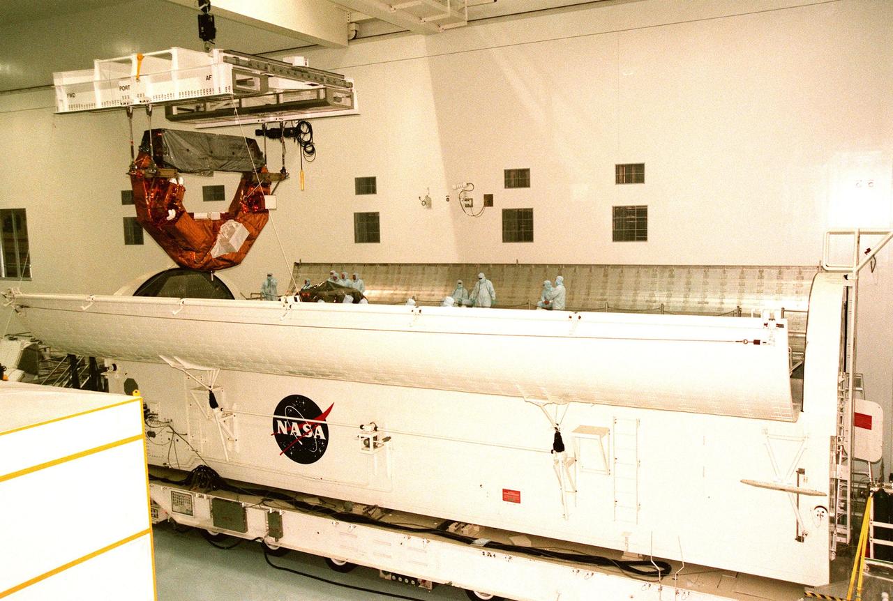 KENNEDY SPACE CENTER, FLA. -- The Hubble Space Telescope Orbiting Systems Test (HOST), one of the payloads on the STS-95 mission, is suspended above its payload canister in the Space Station Processing Facility. The canister is 65 feet long, 18 feet wide and 18 feet, 7 inches high. The HOST platform is carrying four experiments to validate components planned for installation during the third Hubble Space Telescope servicing mission and to evaluate new technologies in an Earth-orbiting environment. The STS-95 mission is scheduled to launch Oct. 29. It will carry other payloads such as the Spartan solar-observing deployable spacecraft, the International Extreme Ultraviolet Hitchhiker (IEH-3), and the SPACEHAB single module with experiments on space flight and the aging process