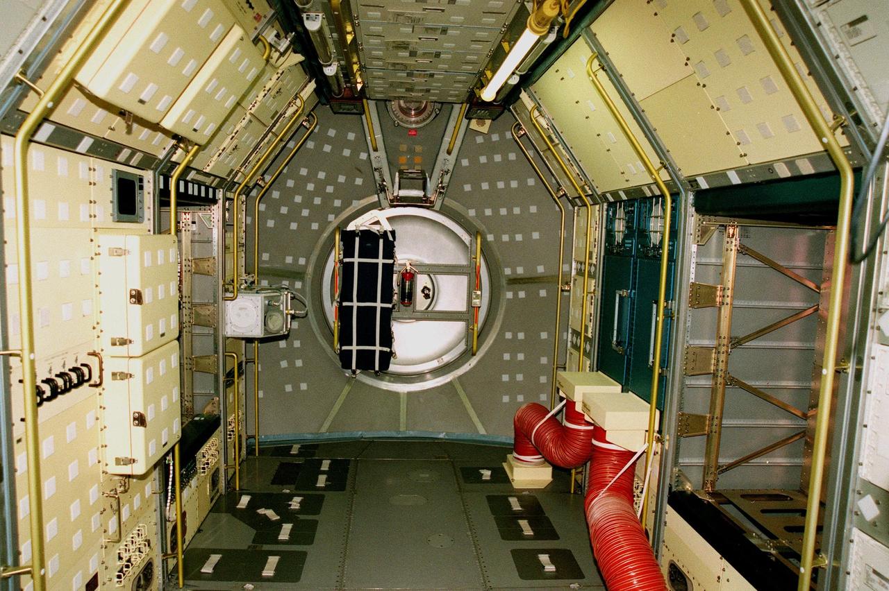Viewed looking aft, this Spacelab module is empty now, being prepared in the Operations & Checkout Building for shipment to the National Air and Space Museum in Washington, DC. Visible on the floor are the foot restraints used by astronauts to keep them stationary while conducting experiments. Spacelab was designed by the European Space Agency (ESA) for the Space Shuttle program. It first flew on STS-9 in November 1983 and its final flight was the STS-90 Neurolab mission in April 1998. The Spacelab concept of modular experiment racks in a pressurized shirt-sleeve environment made it highly user-friendly and accessible. Numerous experiments conceived by hundreds of scientists on the ground were conducted by flight crews in orbit. Spacelab modules served as on-orbit homes for everything from squirrel monkeys to plant seeds. They supported astronomical as well as Earth observations, for servicing the Hubble Space Telescope and for research preparatory to the International Space Station. One of the greatest benefits afforded by the Spacelab missions was the opportunity to fly a mission more than once, with the second or third flight building on the experiences and data gathered from its predecessors