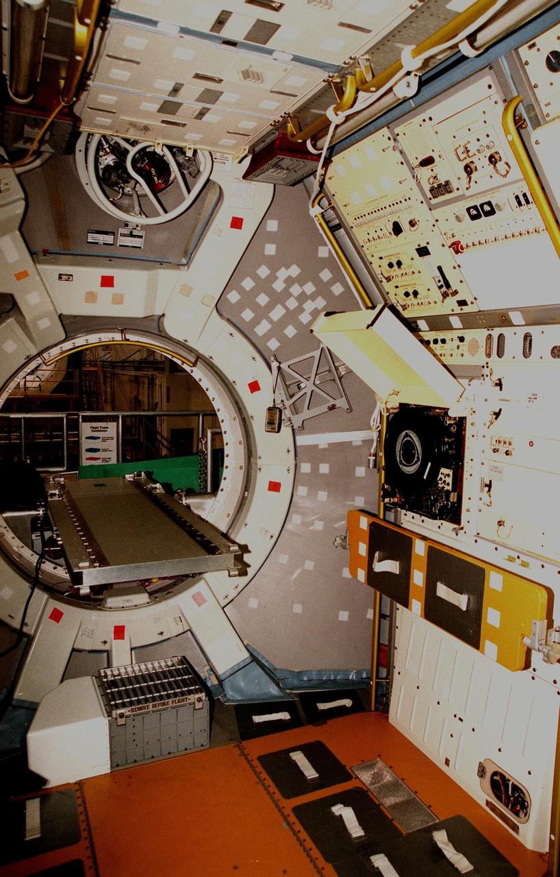 KENNEDY SPACE CENTER, FLA. -- A closeup view of the hatch to this Spacelab module shows an empty interior as the module is being prepared in the Operations & Checkout Building for shipment to the National Air and Space Museum in Washington, DC. Visible on the floor are the foot restraints used by astronauts to keep them stationary while conducting experiments. Spacelab was designed by the European Space Agency (ESA) for the Space Shuttle program. It first flew on STS-9 in November 1983 and its final flight was the  STS-90 Neurolab mission in April 1998. The Spacelab concept of modular experiment racks in a pressurized shirt-sleeve environment made it highly user-friendly and accessible. Numerous experiments conceived by hundreds of scientists on the ground were conducted by flight crews in orbit. Spacelab modules served as on-orbit homes for everything from squirrel monkeys to plant seeds. They supported astronomical as well as Earth observations, for servicing the Hubble Space Telescope and for research preparatory to the International Space Station. One of the greatest benefits afforded by the Spacelab missions was the opportunity to fly a mission more than once, with the second or third flight building on the experiences and data gathered from its predecessors