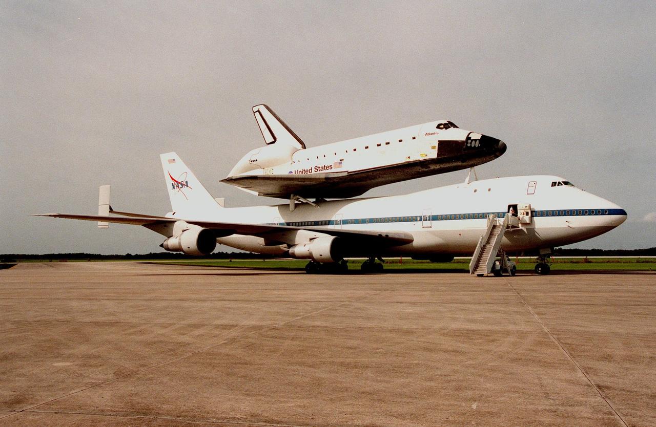 KENNEDY SPACE CENTER, FLA. -- Stairs are rolled to the forward opening of the Shuttle Carrier Aircraft with its piggyback cargo, the orbiter Atlantis after it rolls to a stop at the Shuttle Landing Facility. Atlantis returns home after a 10-month stay in the Palmdale, CA, orbiter processing facility undergoing extensive inspections and modifications. They included several upgrades enabling it to support International Space Station missions, such as adding an external airlock for ISS docking missions and installing thinner, lighter thermal protection blankets for weight reduction which will allow it to haul heavier cargo. The flight from Palmdale included a fueling stop in Ft. Hood, TX, and overnight stay at Ft. Campbell, KY. Atlantis will undergo preparations in the Orbiter Processing Facility at KSC for its planned flight in June 1999
