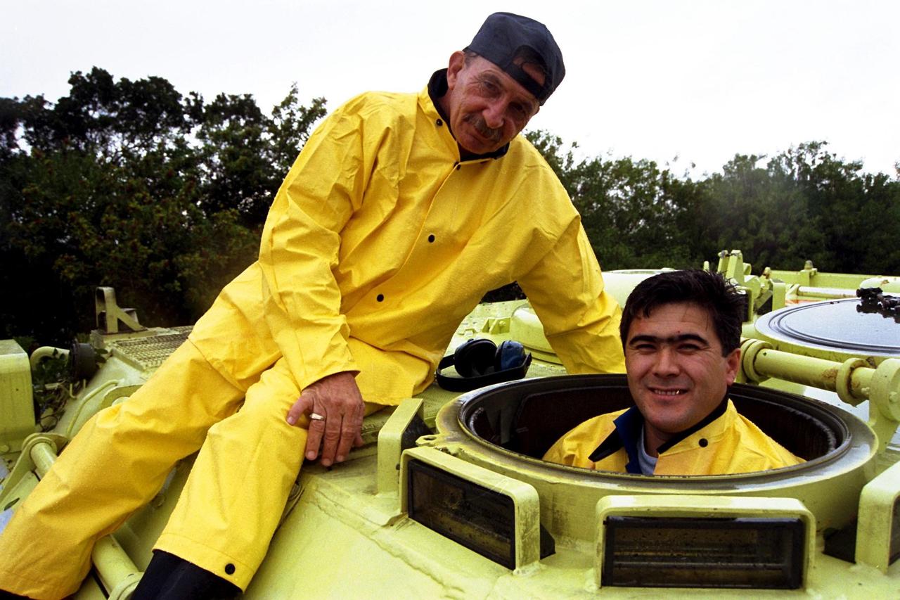 STS-89 Mission Specialist Salizhan Sharipov of the Russian Space Agency gets ready to drive the M-113 armored personnel carrier as part of Terminal Countdown Demonstration Test (TCDT) activities while George Hoggard, a training officer with KSC Fire Services, sits atop the vehicle. The TCDT is held at KSC prior to each Space Shuttle flight to provide crews with an opportunity to participate in simulated countdown activities. The STS-89 mission will be the eighth docking of the Space Shuttle with the Russian Space Station Mir. After docking, STS-89 Mission Specialist Andrew Thomas, Ph.D., will transfer to the space station, succeeding David Wolf, M.D., who will return to Earth aboard Endeavour. Dr. Thomas will live and work on Mir until June. STS-89 is scheduled for a Jan. 22 liftoff at 9:48 p.m