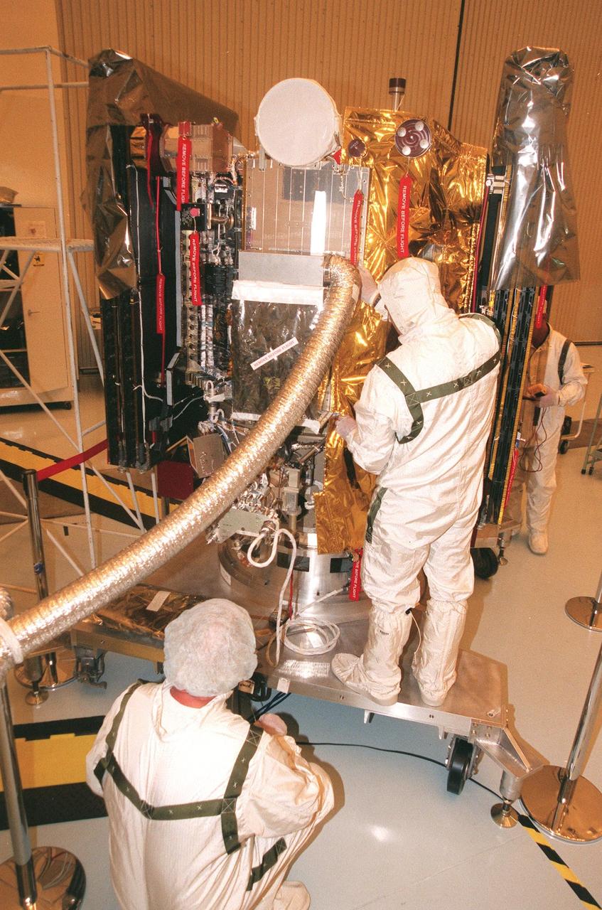 KENNEDY SPACE CENTER, FLA. -- Workers in the Payload Hazardous Servicing Facility begin installing blanket insulation on Deep Space 1. The first flight in NASA's New Millennium Program, Deep Space 1 is designed to validate 12 new technologies for scientific space missions of the next century. Onboard experiments include an ion propulsion engine and software that tracks celestial bodies so the spacecraft can make its own navigation decisions without the intervention of ground controllers. Deep Space 1 will complete most of its mission objectives within the first two months, but may also do a flyby of a near-Earth asteroid, 1992 KD, in July 1999. Deep Space 1 will be launched aboard a Boeing Delta 7326 rocket from Launch Pad 17A, Cape Canaveral Air Station, in October. Delta II rockets are medium capacity expendable launch vehicles derived from the Delta family of rockets built and launched since 1960. Since then there have been more than 245 Delta launches