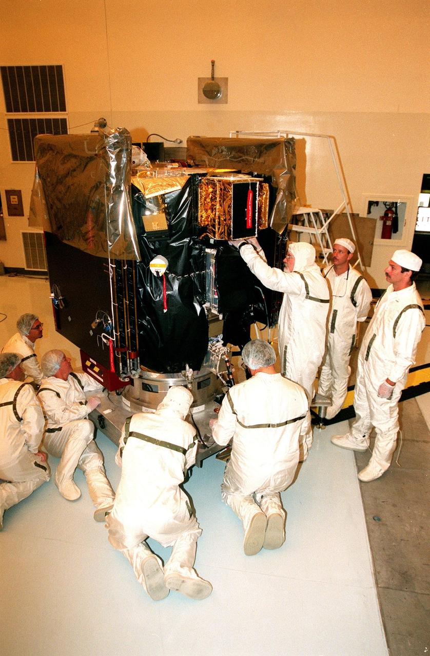KENNEDY SPACE CENTER, FLA. -- Workers in the Payload Hazardous Servicing Facility install blanket insulation on Deep Space 1. The first flight in NASA's New Millennium Program, Deep Space 1 is designed to validate 12 new technologies for scientific space missions of the next century. Onboard experiments include an ion propulsion engine and software that tracks celestial bodies so the spacecraft can make its own navigation decisions without the intervention of ground controllers. Deep Space 1 will complete most of its mission objectives within the first two months, but may also do a flyby of a near-Earth asteroid, 1992 KD, in July 1999. Deep Space 1 will be launched aboard a Boeing Delta 7326 rocket from Launch Pad 17A, Cape Canaveral Air Station, in October. Delta II rockets are medium capacity expendable launch vehicles derived from the Delta family of rockets built and launched since 1960. Since then there have been more than 245 Delta launches