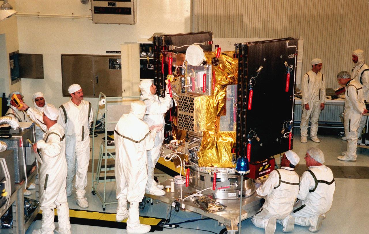 KENNEDY SPACE CENTER, FLA. -- In the Payload Hazardous Servicing Facility, KSC workers place insulating blankets on Deep Space 1 to prepare it for launch. The first flight in NASA's New Millennium Program, Deep Space 1 is designed to validate 12 new technologies for scientific space missions of the next century. Onboard experiments include an ion propulsion engine and software that tracks celestial bodies so the spacecraft can make its own navigation decisions without the intervention of ground controllers. Deep Space 1 will complete most of its mission objectives within the first two months, but may also do a flyby of a near-Earth asteroid, 1992 KD, in July 1999. Deep Space 1 will be launched aboard a Boeing Delta 7326 rocket from Launch Pad 17A, Cape Canaveral Air Station, in October. Delta II rockets are medium capacity expendable launch vehicles derived from the Delta family of rockets built and launched since 1960. Since then there have been more than 245 Delta launches