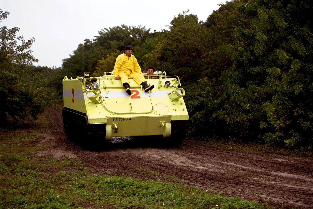 STS-89 Mission Specialist Salizhan Sharipov of the Russian Space Agency drives the M-113 armored personnel carrier as part of Terminal Countdown Demonstration Test (TCDT) activities while George Hoggard, a training officer with KSC Fire Services, gets a free ride. The TCDT is held at KSC prior to each Space Shuttle flight to provide crews with an opportunity to participate in simulated countdown activities. The STS-89 mission will be the eighth docking of the Space Shuttle with the Russian Space Station Mir. After docking, STS-89 Mission Specialist Andrew Thomas, Ph.D., will transfer to the space station, succeeding David Wolf, M.D., who will return to Earth aboard Endeavour. Dr. Thomas will live and work on Mir until June. STS-89 is scheduled for a Jan. 22 liftoff at 9:48 p.m