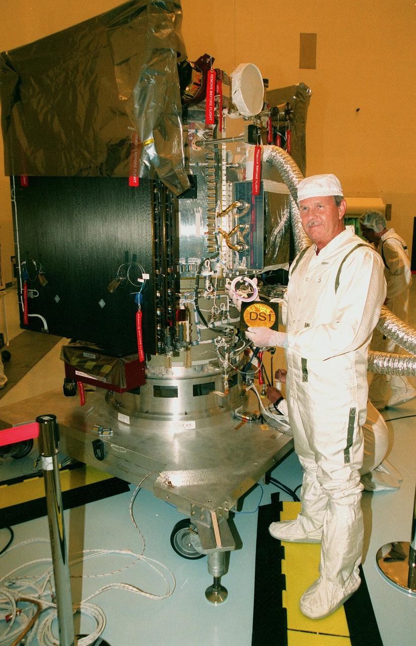KENNEDY SPACE CENTER, FLA. -- In the Payload Hazardous Servicing Facility, Tom Shain, project manager on Deep Space 1, displays a CD containing 350,000 names of KSC workers that he will place in a pouch and insert inside the spacecraft. The first flight in NASA's New Millennium Program, Deep Space 1 is designed to validate 12 new technologies for scientific space missions of the next century. Onboard experiments include an ion propulsion engine and software that tracks celestial bodies so the spacecraft can make its own navigation decisions without the intervention of ground controllers. Deep Space 1 will complete most of its mission objectives within the first two months, but may also do a flyby of a near-Earth asteroid, 1992 KD, in July 1999. Deep Space 1 will be launched aboard a Boeing Delta 7326 rocket from Launch Pad 17A, Cape Canaveral Air Station, in October. Delta II rockets are medium capacity expendable launch vehicles derived from the Delta family of rockets built and launched since 1960. Since then there have been more than 245 Delta launches