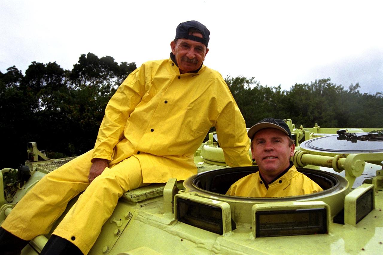 STS-89 Mission Specialist Andrew Thomas, Ph.D. gets ready to drive an M-113 armored personnel carrier as part of Terminal Countdown Demonstration Test (TCDT) activities. The TCDT is held at KSC prior to each Space Shuttle flight to provide crews with an opportunity to participate in simulated countdown activities. Standing inside the M-113 is Dr. Thomas while George Hoggard, a training officer with KSC Fire Services, sits atop the vehicle. The STS-89 mission will be the eighth docking of the Space Shuttle with the Russian Space Station Mir. After docking, Dr. Thomas will transfer to the space station, succeeding David Wolf, M.D., who will return to Earth aboard Endeavour. Dr. Thomas will live and work on Mir until June. STS-89 is scheduled for a Jan. 22 liftoff at 9:48 p.m