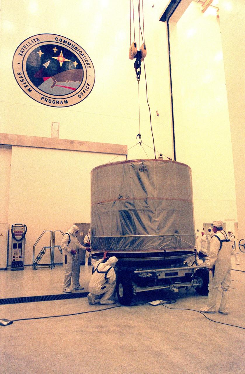 Workers at this clean room facility, Cape Canaveral Air Station, prepare to lift the protective can that covered Deep Space 1 during transportation from KSC. The spacecraft will undergo spin testing at the site. Deep Space 1, the first flight in NASA's New Millennium Program, is designed to validate 12 new technologies for scientific space missions of the next century. Onboard experiments include a solar-powered ion propulsion engine and software that tracks celestial bodies so the spacecraft can make its own navigation decisions without the intervention of ground controllers. The ion propulsion engine is the first non-chemical propulsion to be used as the primary means of propelling a spacecraft. Deep Space 1 will complete most of its mission objectives within the first two months, but may also do a flyby of a near-Earth asteroid, 1992 KD, in July 1999. The spacecraft will be launched aboard a Boeing Delta 7326 rocket from Launch Pad 17A, Cape Canaveral Air Station, in October. Delta II rockets are medium capacity expendable launch vehicles derived from the Delta family of rockets built and launched since 1960. Since then there have been more than 245 Delta launches