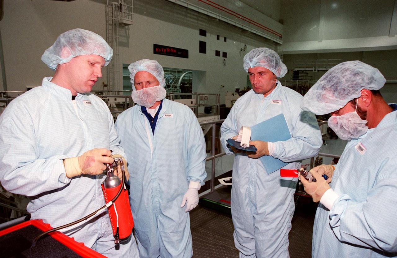 (Left to right) Bob Behrendsen, Mod Flight Crew Systems, astronaut Kenneth Bowersox and cosmonaut Vladimir Dezhurov check out equipment for the International Space Station (ISS) in the Space Station Processing Facility. Bowersox and Dezhurov are targeted on mission STS-102 which is scheduled to transport the second Multi-Purpose Logistics Module to ISS