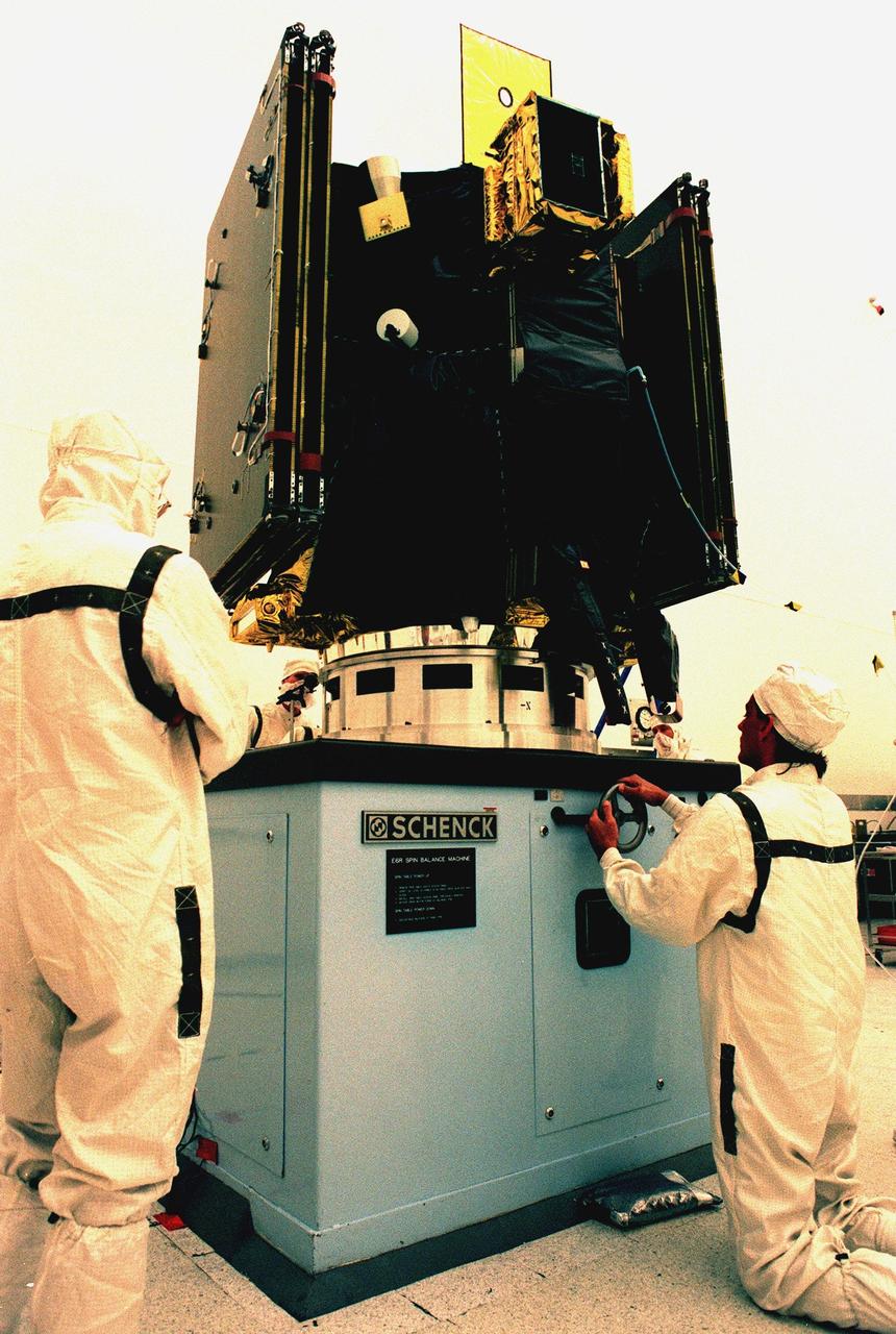 KENNEDY SPACE CENTER, FLA. -- KSC workers give a final check to Deep Space 1 before starting a spin test on the spacecraft at the Defense Satellite Communications System Processing Facility (DPF), Cape Canaveral Air Station. The first flight in NASA's New Millennium Program, Deep Space 1 is designed to validate 12 new technologies for scientific space missions of the next century. Onboard experiments include a solar-powered ion propulsion engine and software that tracks celestial bodies so the spacecraft can make its own navigation decisions without the intervention of ground controllers. The ion propulsion engine is the first non-chemical propulsion to be used as the primary means of propelling a spacecraft. Deep Space 1 will complete most of its mission objectives within the first two months, but may also do a flyby of a near-Earth asteroid, 1992 KD, in July 1999. The spacecraft will be launched aboard a Boeing Delta 7326 rocket from Launch Pad 17A, Cape Canaveral Air Station, in October. Delta II rockets are medium capacity expendable launch vehicles derived from the Delta family of rockets built and launched since 1960. Since then there have been more than 245 Delta launches