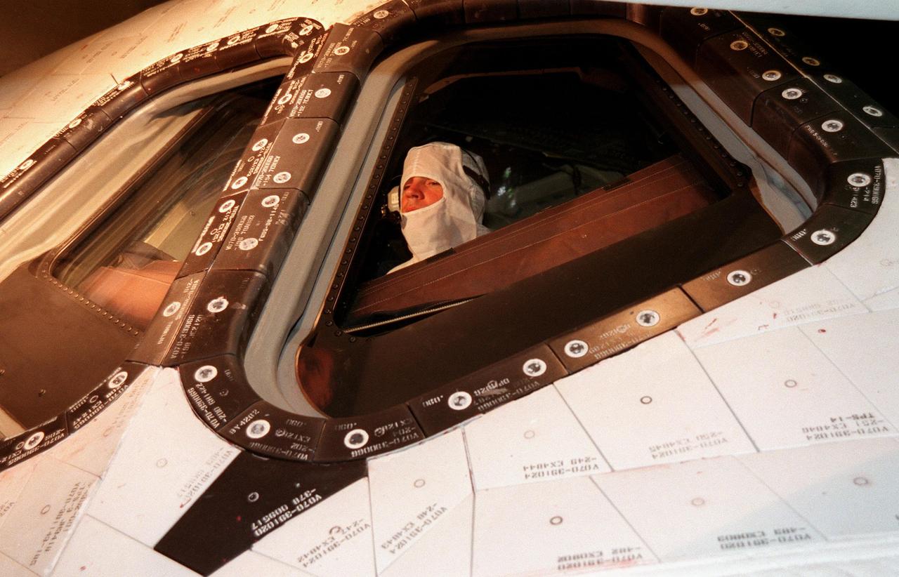 KENNEDY SPACE CENTER, FLA. -- In the Orbiter Processing Facility Bay 1, STS-88 Pilot Frederick W. Sturckow makes a visual inspection of windows on the Space Shuttle orbiter Endeavour. The STS-88 crew members are participating in a Crew Equipment Interface Test (CEIT), familiarizing themselves with the orbiter's midbody and crew compartments. Targeted for launch on Dec. 3, 1998, STS-88 will be the first Space Shuttle launch for assembly of the International Space Station (ISS). The primary payload is the Unity connecting module which will be mated to the Russian-built Zarya control module, expected to be already on orbit after a November launch from Russia. The first major U.S.-built component of ISS, Unity will serve as a connecting passageway to living and working areas of the space station. Unity has two attached pressurized mating adapters (PMAs) and one stowage rack installed inside. PMA-1 provides the permanent connection point between Unity and Zarya; PMA-2 will serve as a Space Shuttle docking port. Zarya is a self-supporting active vehicle, providing propulsive control capability and power during the early assembly stages. It also has fuel storage capability