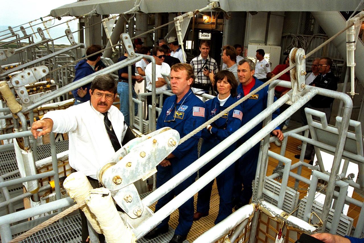 KENNEDY SPACE CENTER, Fla. -- Jim Bell, USA senior instructor for technical training, explains the emergency egress system at KSC’s Launch Pad 39A to, left to right, STS-89 Mission Specialists Andrew Thomas, Ph.D., who will transfer to the Russian Space Station Mir, and Bonnie Dunbar, Ph.D., as well as to Commander Terrence Wilcutt. Dr. Thomas will succeed David Wolf, M.D., who will return to Earth aboard Endeavour. The seven astronauts assigned to the eighth Shuttle-Mir docking flight are completing Terminal Countdown Demonstration Test (TCDT) activities at KSC. A dress rehearsal for launch, the TCDT includes emergency egress training at the launch pad and culminates with a simulated countdown. The Space Shuttle Endeavour is undergoing preparations for liftoff, scheduled for Jan. 22. Dr. Thomas will live and work on Mir until June