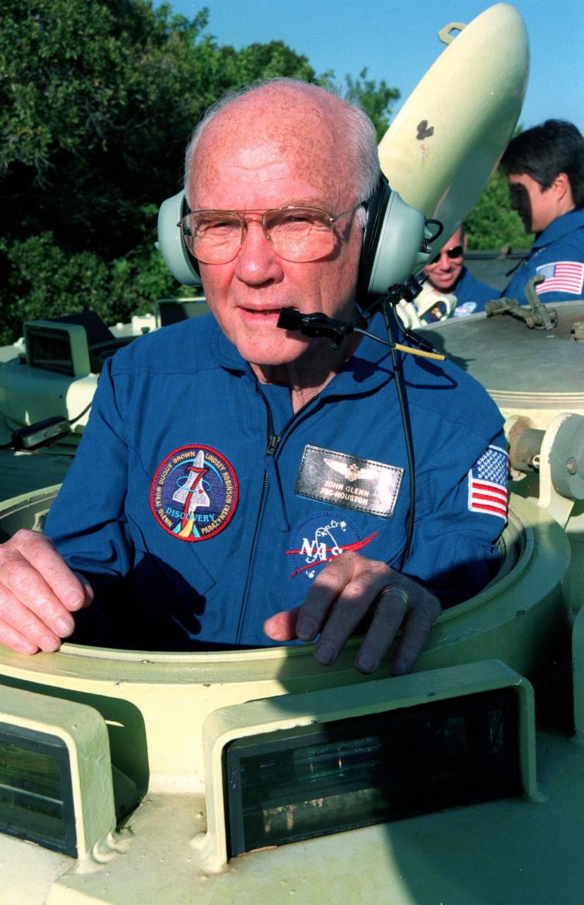 Near Launch Pad 39-B, STS-95 Payload Specialist John H. Glenn Jr. climbs into an M-113, a small armored personnel carrier, that is part of emergency egress training. The tracked vehicle could be used by the crew in the event of an emergency at the pad during which the crew must make a quick exit from the area. The STS-95 crew is at KSC to participate in a Test Countdown Demonstration Test (TCDT) which also includes mission familiarization activities and a simulated main engine cut-off exercise. The other members on the mission are Mission Commander Curtis L. Brown, Pilot Steven W. Lindsey, Mission Specialists Scott E. Parazynski, Stephen K. Robinson, and Pedro Duque of Spain, representing the European Space Agency (ESA); and Payload Specialist Chiaki Mukai, representing the National Space Development Agency of Japan (NASDA). The STS-95 mission, targeted for liftoff on Oct. 29, includes research payloads such as the Spartan solar-observing deployable spacecraft, the Hubble Space Telescope Orbital Systems Test Platform, the International Extreme Ultraviolet Hitchhiker, as well as the SPACEHAB single module with experiments on space flight and the aging process