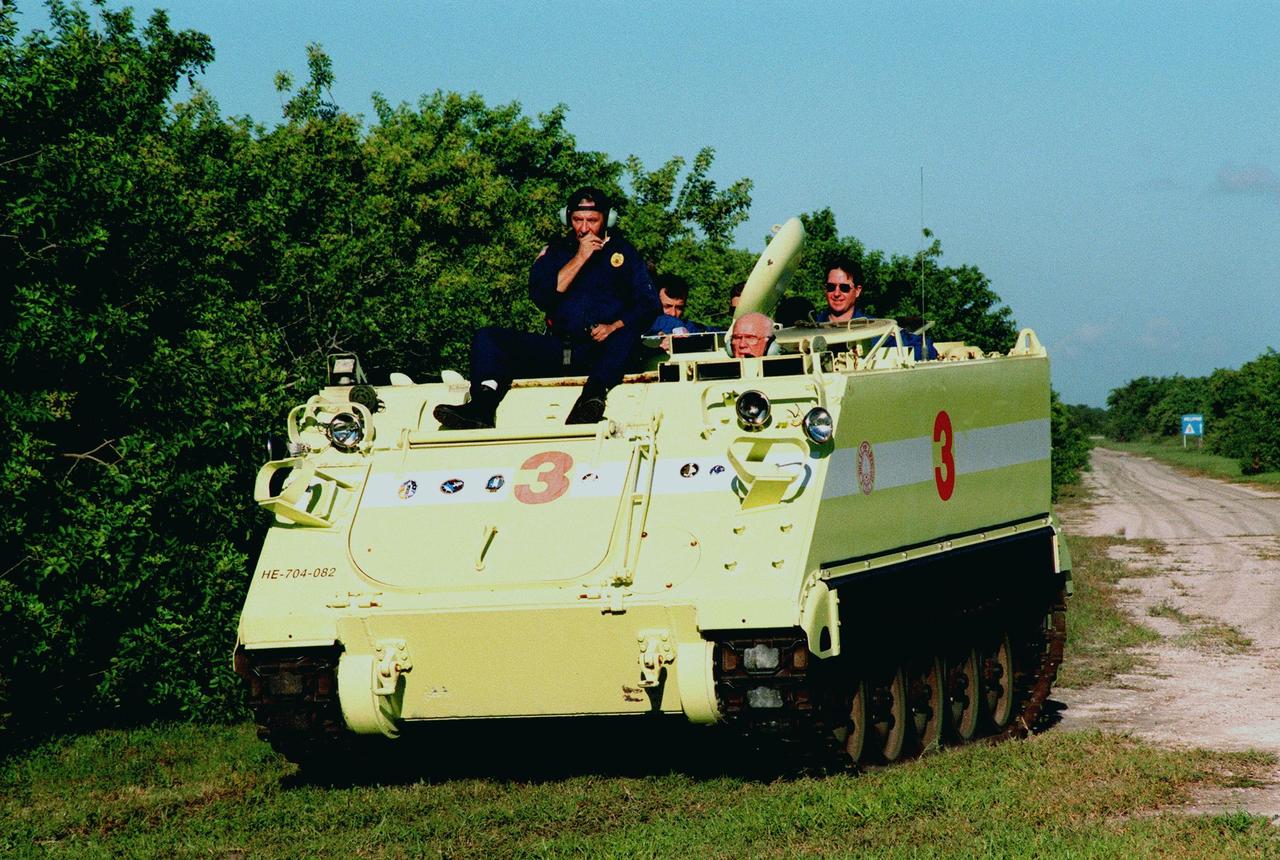 Under the watchful eye of Capt. George Hoggard, trainer with the KSC Fire Department, STS-95 crew members participate in training on the M-113, a small armored personnel carrier, that is part of emergency egress training. Payload Specialist John H. Glenn Jr. (front right) drives, with Mission Specialists Pedro Duque of Spain (left) and Stephen K. Robinson (right) as passengers. Duque represents the European Space Agency (ESA). The tracked vehicle could be used by the crew in the event of an emergency at the pad during which the crew must make a quick exit from the area. The STS-95 crew is at KSC to participate in a Terminal Countdown Demonstration Test (TCDT) which also includes mission familiarization activities and a simulated main engine cut-off exercise. The other members on the mission are Mission Commander Curtis L. Brown, Pilot Steven W. Lindsey, Mission Specialist Scott E. Parazynski; and Payload Specialist Chiaki Mukai, representing the National Space Development Agency of Japan (NASDA). STS-95, which is targeted for launch on Oct. 29, 1998, includes research payloads such as the Spartan solar-observing deployable spacecraft, the Hubble Space Telescope Orbital Systems Test Platform, the International Extreme Ultraviolet Hitchhiker, as well as the SPACEHAB single module with experiments on space flight and the aging process