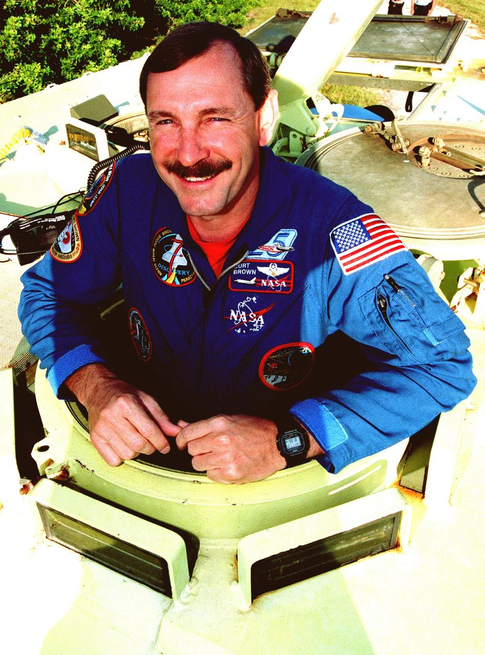 Near Launch Pad 39-B, STS-95 Mission Commander Curtis L. Brown climbs into the M-113, a small armored personnel carrier, that is part of emergency egress training. The tracked vehicle could be used by the crew in the event of an emergency at the pad during which the crew must make a quick exit from the area. The STS-95 crew is at KSC to participate in a Terminal Countdown Demonstration Test (TCDT) which also includes mission familiarization activities and a simulated main engine cut-off exercise. The other members on the mission are Pilot Steven W. Lindsey, Mission Specialists Scott E. Parazynski, Stephen K. Robinson and Pedro Duque of Spain, representing the European Space Agency (ESA), and Payload Specialists John H. Glenn Jr., senator from Ohio, and Chiaki Mukai, representing the National Space Development Agency of Japan (NASDA). The STS-95 mission, targeted for liftoff on Oct. 29, includes research payloads such as the Spartan solar-observing deployable spacecraft, the Hubble Space Telescope Orbital Systems Test Platform, the International Extreme Ultraviolet Hitchhiker, as well as the SPACEHAB single module with experiments on space flight and the aging process