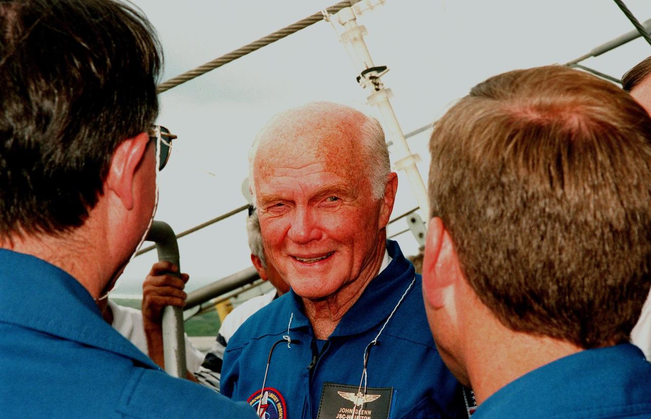 At Launch Pad 39-B, at the 195-foot level, STS-95 Payload Specialist John H. Glenn Jr., senator from Ohio, takes a moment from emergency egress training to talk to (left) Mission Specialist Stephen K. Robinson and Pilot Steven W. Lindsey (right). The STS-95 crew are at KSC to participate in a Terminal Countdown Demonstration Test (TCDT) which includes mission familiarization activities, emergency egress training, and a simulated main engine cut-off exercise. Other crew members are Mission Specialist Scott E. Parazynski, Mission Specialist Pedro Duque of Spain, representing the European Space Agency (ESA), Mission Specialist Payload Specialist Chiaki Mukai, representing the National Space Development Agency of Japan (NASDA), and Mission Commander Curtis L. Brown. The STS-95 mission, targeted for liftoff on Oct. 29, includes research payloads such as the Spartan solar-observing deployable spacecraft, the Hubble Space Telescope Orbital Systems Test Platform, the International Extreme Ultraviolet Hitchhiker, as well as the SPACEHAB single module with experiments on space flight and the aging process. Following the TCDT, the crew will be returning to Houston for final flight preparations