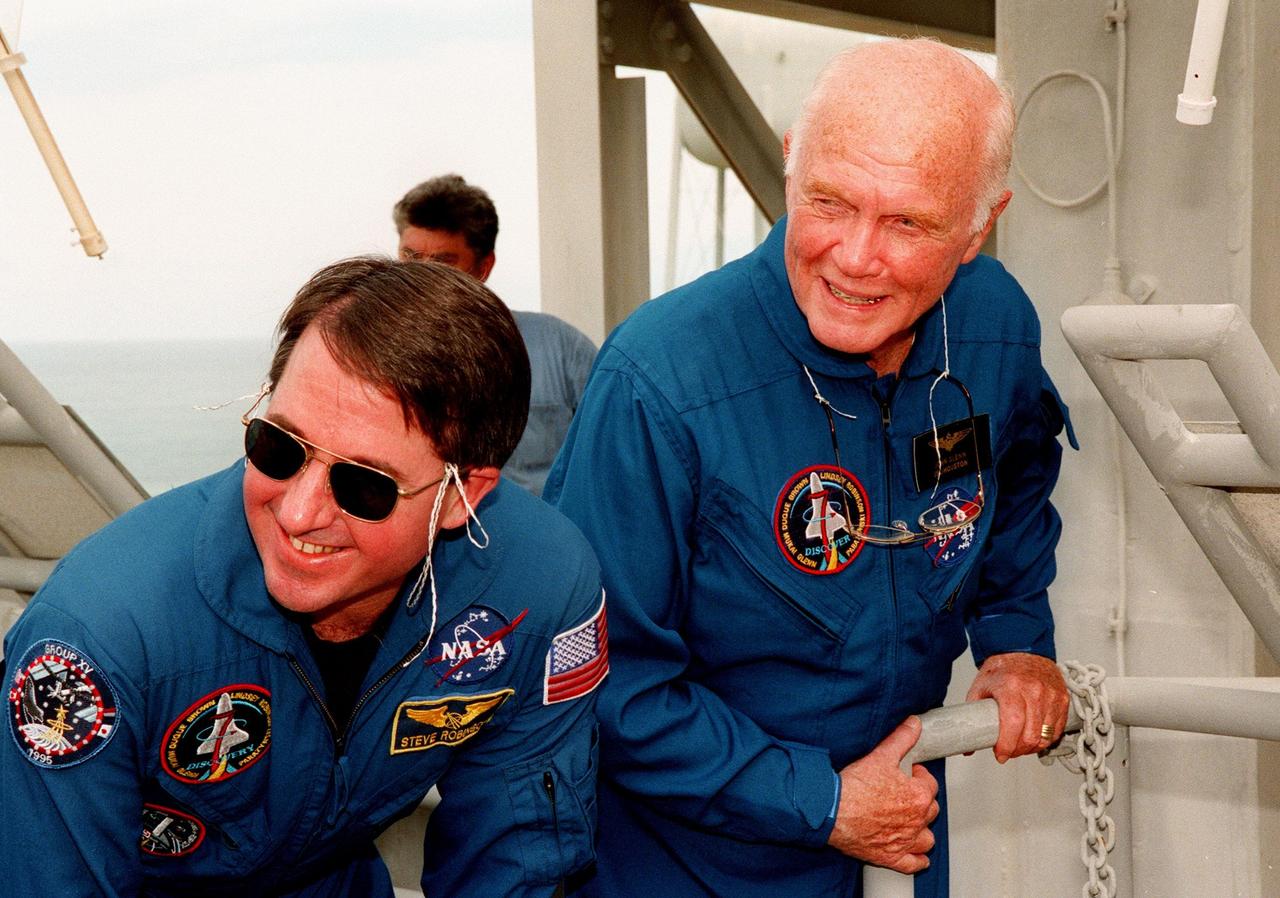 STS-95 Payload Specialist John H. Glenn Jr. and Mission Specialist Stephen K. Robinson watch the progress of the slidewire basket, an emergency egress vehicle, Glenn released at the 195-foot level of Launch Pad 39-B. The STS-95 crew are at KSC to participate in a Terminal Countdown Demonstration Test (TCDT) which includes mission familiarization activities, emergency egress training, and a simulated main engine cut-off exercise. Other crew members are Mission Specialist Scott E. Parazynski, Mission Specialist Pedro Duque of Spain, representing the European Space Agency (ESA), Pilot Steven W. Lindsey, Payload Specialist Chiaki Mukai, representing the National Space Development Agency of Japan (NASDA), and Mission Commander Curtis L. Brown. The STS-95 mission, targeted for liftoff on Oct. 29, includes research payloads such as the Spartan solar-observing deployable spacecraft, the Hubble Space Telescope Orbital Systems Test Platform, the International Extreme Ultraviolet Hitchhiker, as well as the SPACEHAB single module with experiments on space flight and the aging process. Following the TCDT, the crew will be returning to Houston for final flight preparations