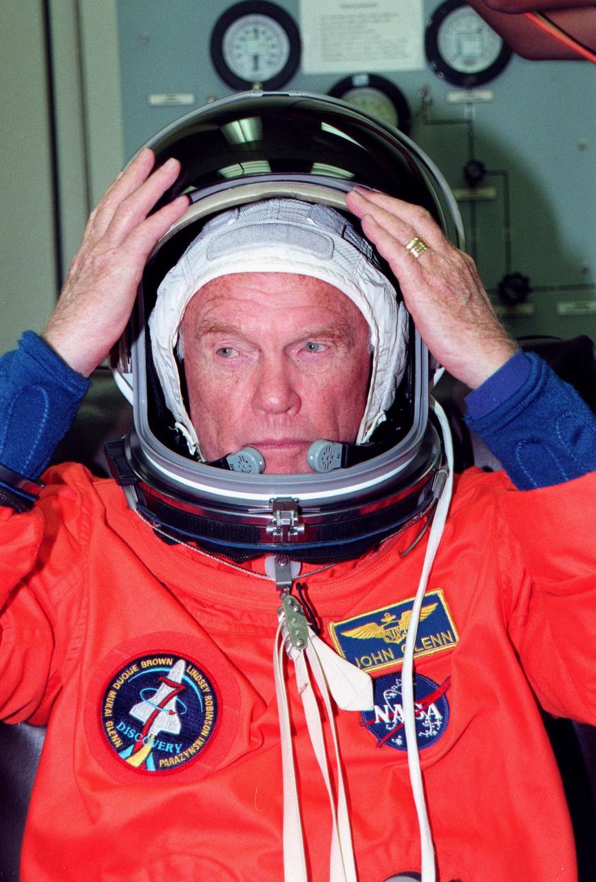 STS-95 Payload Specialist John H. Glenn Jr., a senator from Ohio and one of the original seven Project Mercury astronauts, adjusts his helmet during suitup in the Operations and Checkout (O&C) Building prior to his trip to Launch Pad 39-B. Glenn and the rest of the STS-95 crew are at KSC to participate in the Terminal Countdown Demonstration Test (TCDT) which includes mission familiarization activities, emergency egress training, and a simulated main engine cutoff. The other crew members are Payload Specialist Chiaki Mukai (M.D., Ph.D.), representing the National Space Development Agency of Japan (NASDA), Pilot Steven W. Lindsey, Mission Specialist Scott E. Parazynski, Mission Specialist Stephen K. Robinson, Mission Specialist Pedro Duque of Spain, representing the European Space Agency (ESA), and Mission Commander Curtis L. Brown. The STS-95 mission, targeted for liftoff on Oct. 29, includes research payloads such as the Spartan solar-observing deployable spacecraft, the Hubble Space Telescope Orbital Systems Test Platform, the International Extreme Ultraviolet Hitchhiker, as well as the SPACEHAB single module with experiments on space flight and the aging process. Following the TCDT, the crew will be returning to Houston for final flight preparations
