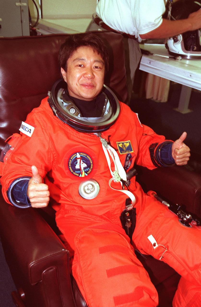 STS-95 Payload Specialist Chiaki Mukai (M.D., Ph.D.), representing the National Space Development Agency of Japan (NASDA), gives a two-thumbs up salute while suiting up in the Operations and Checkout Building prior to her trip to Launch Pad 39-B. Mukai and the rest of the STS-95 crew are at KSC to participate in the Terminal Countdown Demonstration Test (TCDT) which includes mission familiarization activities, emergency egress training, and a simulated main engine cutoff. The other crew members are Pilot Steven W. Lindsey, Mission Specialist Scott E. Parazynski, Mission Specialist Stephen K. Robinson, Mission Specialist Pedro Duque of Spain, representing the European Space Agency (ESA), Payload Specialist John H. Glenn Jr., senator from Ohio, and Mission Commander Curtis L. Brown. The STS-95 mission, targeted for liftoff on Oct. 29, includes research payloads such as the Spartan solar-observing deployable spacecraft, the Hubble Space Telescope Orbital Systems Test Platform, the International Extreme Ultraviolet Hitchhiker, as well as the SPACEHAB single module with experiments on space flight and the aging process. Following the TCDT, the crew will be returning to Houston for final flight preparations