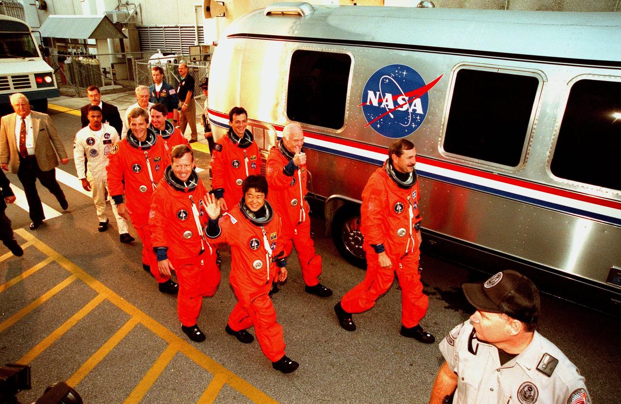 STS-95 crew members exit the Operations & Checkout Building after suiting up for their practice countdown at Launch Pad 39-B. Pictured are (front) Mission Specialist Scott E. Parazynski, Pilot Steven W. Lindsey, Payload Specialist Chiaki Mukai (M.D., Ph.D.), representing the National Space Development Agency of Japan (NASDA); (back) Mission Specialist Stephen K. Robinson, Mission Specialist Pedro Duque of Spain, representing the European Space Agency (ESA), Payload Specialist John H. Glenn Jr., senator from Ohio, and Mission Commander Curtis L. Brown. The STS-95 crew are at KSC to participate in a Terminal Countdown Demonstration Test (TCDT) which includes mission familiarization activities, emergency egress training, and the simulated main engine cut-off exercise. The STS-95 mission, targeted for liftoff on Oct. 29, includes research payloads such as the Spartan solar-observing deployable spacecraft, the Hubble Space Telescope Orbital Systems Test Platform, the International Extreme Ultraviolet Hitchhiker, as well as the SPACEHAB single module with experiments on space flight and the aging process. Following the TCDT, the crew will be returning to Houston for final flight preparations