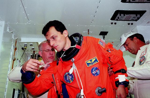 STS-95 Mission Specialist Pedro Duque of Spain, representing the European Space Agency (ESA) is checked by Danny Wyatt (left), with KSC, and Dave Martin (right), with United Space Alliance, in the white room before entry into Space Shuttle Discovery for a pre-launch countdown exercise. Duque and other crew members are at KSC to participate in the Terminal Countdown Demonstration Test (TCDT) which includes mission familiarization activities, emergency egress training, and a simulated main engine cutoff. The other crew members are Payload Specialist Chiaki Mukai (M.D., Ph.D.), representing the National Space Development Agency of Japan (NASDA), Pilot Steven W. Lindsey, Mission Specialist Scott E. Parazynski, Mission Specialist Stephen K. Robinson, Payload Specialist John H. Glenn Jr., senator from Ohio, and Mission Commander Curtis L. Brown. The STS-95 mission, targeted for liftoff on Oct. 29, includes research payloads such as the Spartan solar-observing deployable spacecraft, the Hubble Space Telescope Orbital Systems Test Platform, the International Extreme Ultraviolet Hitchhiker, as well as the SPACEHAB single module with experiments on space flight and the aging process. Following the TCDT, the crew will be returning to Houston for final flight preparations