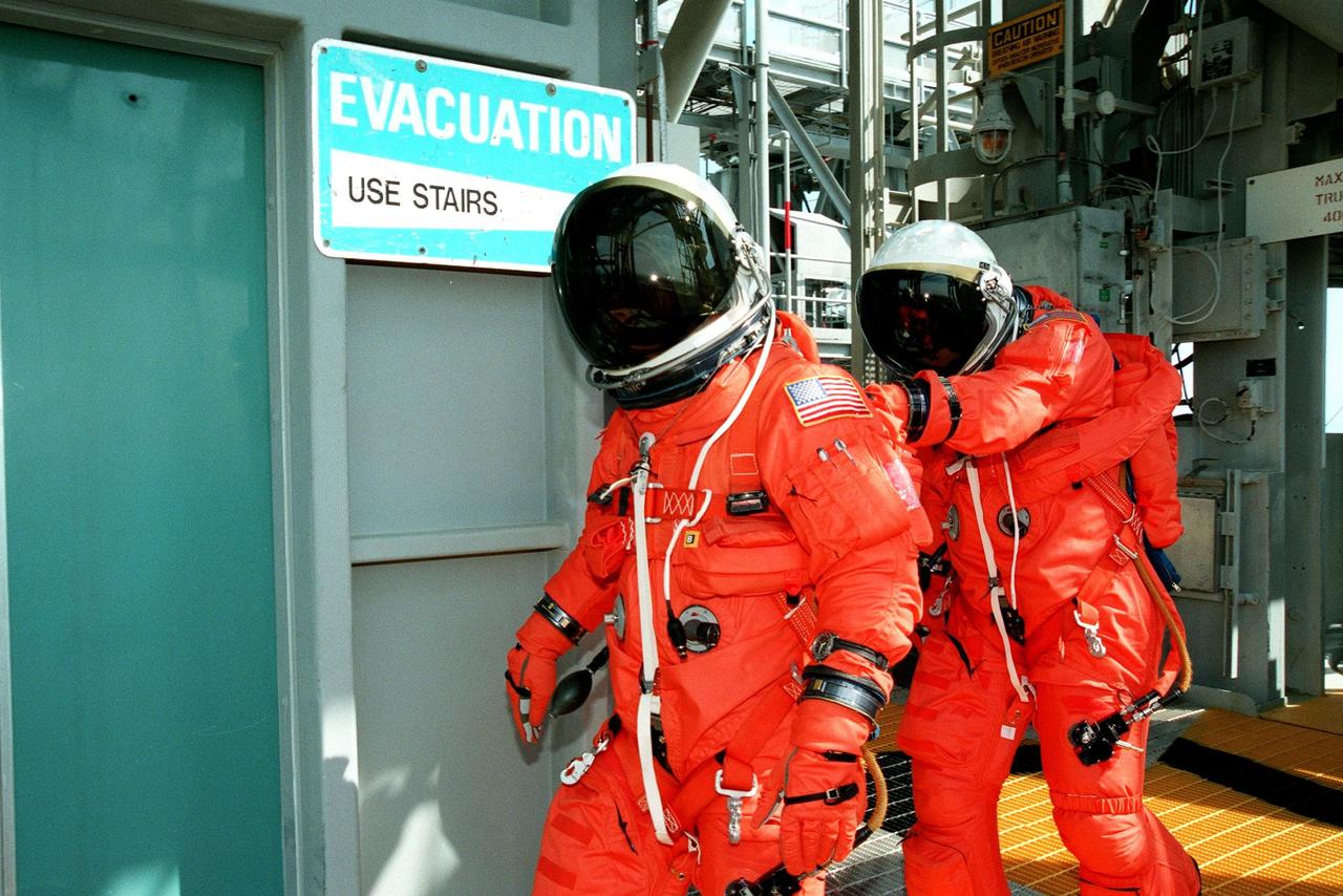 Behind the dark visors of their helmets are STS-95 Mission Commander Curtis L. Brown (left) and Pilot Steven W. Lindsey (right), practicing emergency egress from the Space Shuttle Discovery. Brown and Lindsey, along with the rest of the STS-95 crew, are at KSC to participate in the Terminal Countdown Demonstration Test (TCDT) which includes mission familiarization activities, emergency egress training, and a simulated main engine cutoff. The other crew members are Mission Specialist Scott E. Parazynski, Mission Specialist Pedro Duque of Spain, representing the European Space Agency (ESA), Mission Specialist Stephen K. Robinson, Payload Specialists John H. Glenn Jr., senator from Ohio, and Chiaki Mukai (M.D., Ph.D.), representing the National Space Development Agency of Japan (NASDA). The STS-95 mission, targeted for liftoff on Oct. 29, includes research payloads such as the Spartan solar-observing deployable spacecraft, the Hubble Space Telescope Orbital Systems Test Platform, the International Extreme Ultraviolet Hitchhiker, as well as the SPACEHAB single module with experiments on space flight and the aging process. Following the TCDT, the crew will be returning to Houston for final flight preparations