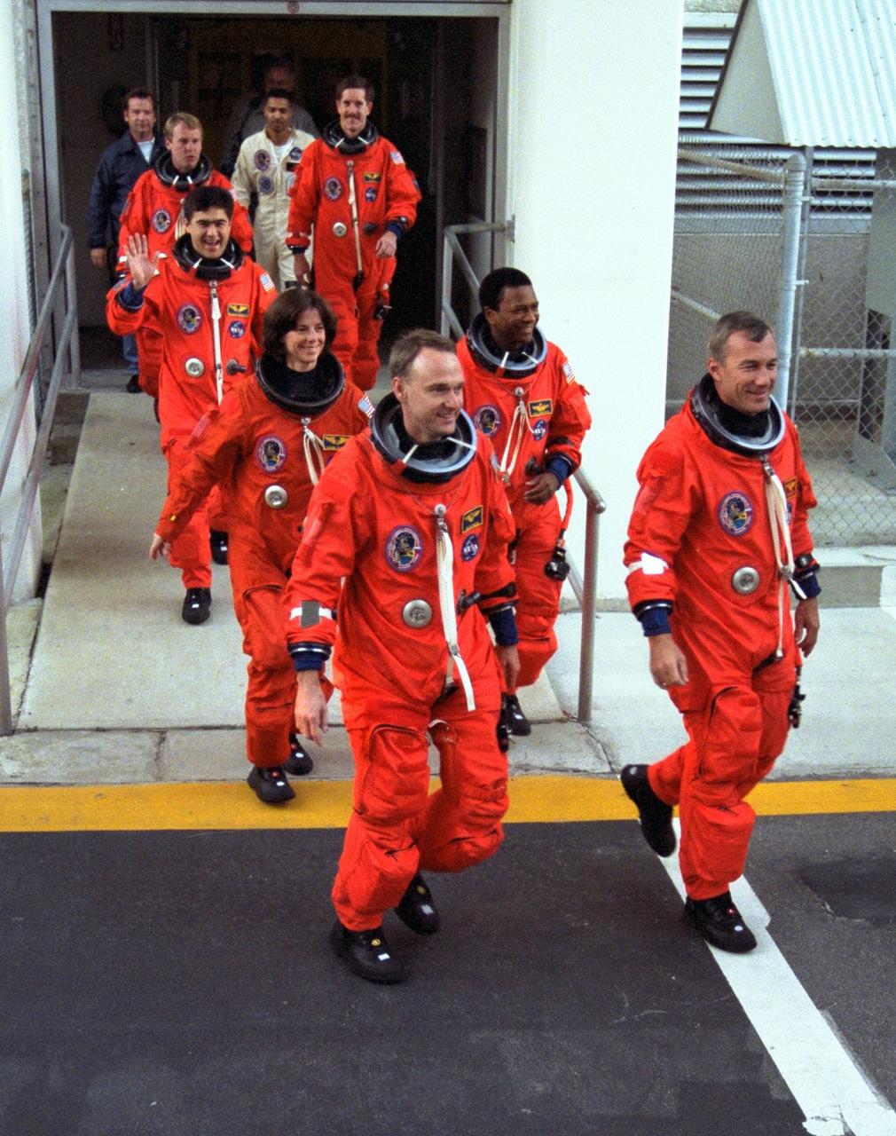 The crew of the STS-89 mission, scheduled for launch Jan. 22 aboard the Space Shuttle Endeavour from pad 39A at Kennedy Space Center (KSC), participated in the Terminal Countdown Demonstration Test (TCDT) at KSC. Simulating the walk-out from the Operations and Checkout Building before entering a van to take them to the launch pad are (front to back, left to right) Pilot Joe Edwards Jr.; Commander Terrence Wilcutt; and Mission Specialists Bonnie Dunbar, Ph.D., Michael Anderson, Salizhan Sharipov of the Russian Space Agency, Andrew Thomas, Ph.D., and James Reilly, Ph.D. The TCDT is held at KSC prior to each Space Shuttle flight to provide the crew of each mission with an opportunity to participate in simulated countdown activities. The TCDT ends with a mock launch countdown culminating in a simulated main engine cut-off. The crew also spends time undergoing emergency egress training exercises at the pad and has an opportunity to view and inspect the payloads in the orbiter's payload bay