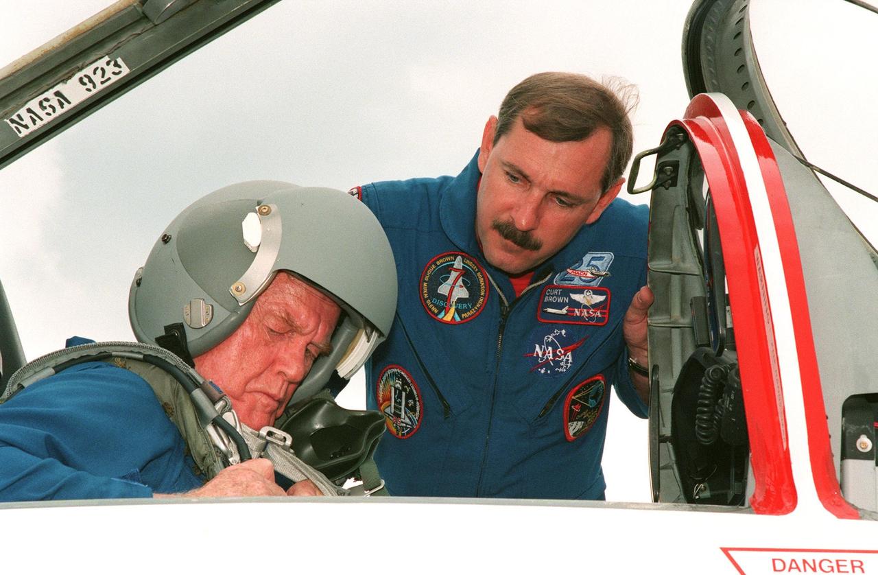STS-95 Payload Specialist John H. Glenn Jr., senator from Ohio, straps into the seat of the T-38 jet aircraft that will carry him back to Houston. Mission Commander Curtis L. Brown, his pilot on the jet, looks on. The STS-95 successfully completed their Terminal Countdown Demonstration Test (TCDT) which included mission familiarization activities, emergency egress training, and a simulated main engine cutoff. Other crew members participating were Pilot Steven W. Lindsey, Mission Specialist Stephen K. Robinson, Payload Specialist Chiaki Mukai (M.D., Ph.D.), representing the National Space Development Agency of Japan (NASDA), Mission Specialist Pedro Duque of Spain, representing the European Space Agency (ESA), and Mission Specialist Scott E. Parazynski. The STS-95 mission, targeted for liftoff on Oct. 29, includes research payloads such as the Spartan solar-observing deployable spacecraft, the Hubble Space Telescope Orbital Systems Test Platform, the International Extreme Ultraviolet Hitchhiker, as well as the SPACEHAB single module with experiments on space flight and the aging process. Following the TCDT, the entire crew returned to Houston for final flight preparations