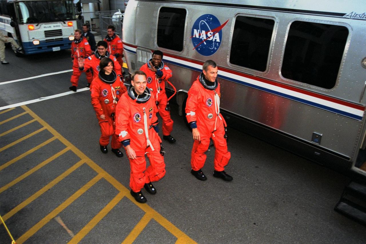 The crew of the STS-89 mission, scheduled for launch Jan. 22 aboard the Space Shuttle Endeavour from pad 39A at Kennedy Space Center (KSC), participated in the Terminal Countdown Demonstration Test (TCDT) at KSC. Simulating the walk-out from the Operations and Checkout Building before entering a van to take them to the launch pad are (front to back, left to right) Pilot Joe Edwards Jr.; Commander Terrence Wilcutt; and Mission Specialists Bonnie Dunbar, Ph.D., Michael Anderson, Salizhan Sharipov of the Russian Space Agency, Andrew Thomas, Ph.D., and James Reilly, Ph.D. The TCDT is held at KSC prior to each Space Shuttle flight to provide the crew of each mission with an opportunity to participate in simulated countdown activities. The TCDT ends with a mock launch countdown culminating in a simulated main engine cut-off. The crew also spends time undergoing emergency egress training exercises at the pad and has an opportunity to view and inspect the payloads in the orbiter's payload bay