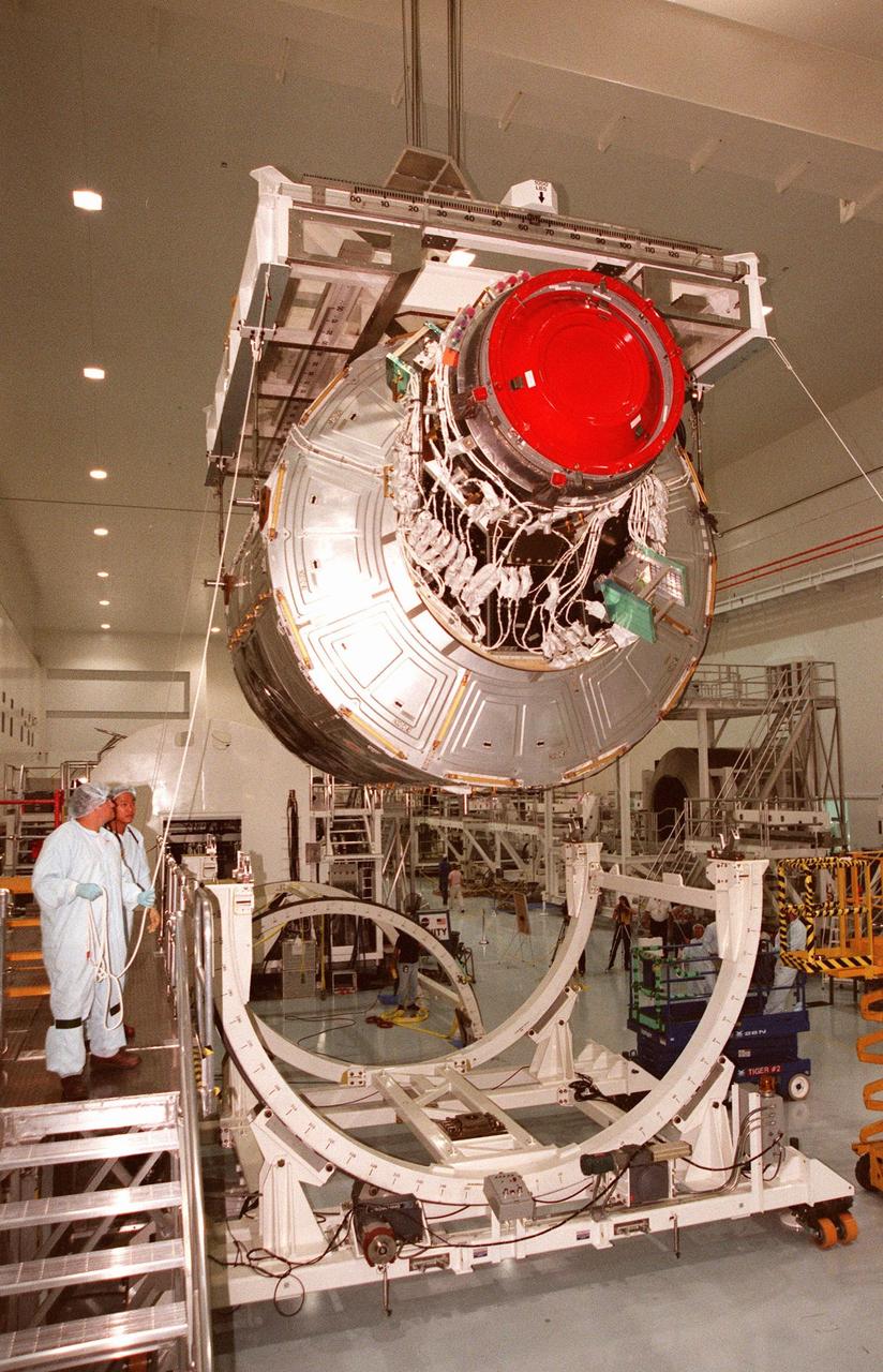 KENNEDY SPACE CENTER, FLA. -- Workers in the Space Station Processing Facility (SSPF) oversee the lifting of the Unity connecting module, part of the International Space Station, for its move to another location in the SSPF. As the primary payload on mission STS-88, scheduled to launch Dec. 3, 1998, Unity will be mated to the Russian-built Zarya control module which should already be in orbit at that time. In the SSPF, Unity is undergoing testing such as the Pad Demonstration Test to verify the compatibility of the module with the Space Shuttle, as well as the ability of the astronauts to send and receive commands to Unity from the flight deck of the orbiter, and the common berthing mechanism to which other space station elements will dock. Unity is expected to be ready for installation into the Shuttle's payload canister on Oct. 25, and transported to Launch Pad 39-A on Oct. 27