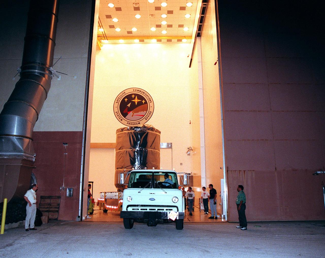 KENNEDY SPACE CENTER, FLA. -- Wrapped in an anti-static blanket for protection, Deep Space 1 is moved out of the Defense Satellite Communications Systems Processing Facility (DPF) at Cape Canaveral Air Station (CCAS) for its trip to Launch Pad 17A. The spacecraft will be launched aboard a Boeing Delta 7326 rocket on Oct. 25. Deep Space 1 is the first flight in NASA's New Millennium Program, and is designed to validate 12 new technologies for scientific space missions of the next century, including the engine. Propelled by the gas xenon, the engine is being flight-tested for future deep space and Earth-orbiting missions. Deceptively powerful, the ion drive emits only an eerie blue glow as ionized atoms of xenon are pushed out of the engine. While slow to pick up speed, over the long haul it can deliver 10 times as much thrust per pound of fuel as liquid or solid fuel rockets. Other onboard experiments include software that tracks celestial bodies so the spacecraft can make its own navigation decisions without the intervention of ground controllers. Deep Space 1 will complete most of its mission objectives within the first two months, but will also do a flyby of a near-Earth asteroid, 1992 KD, in July 1999