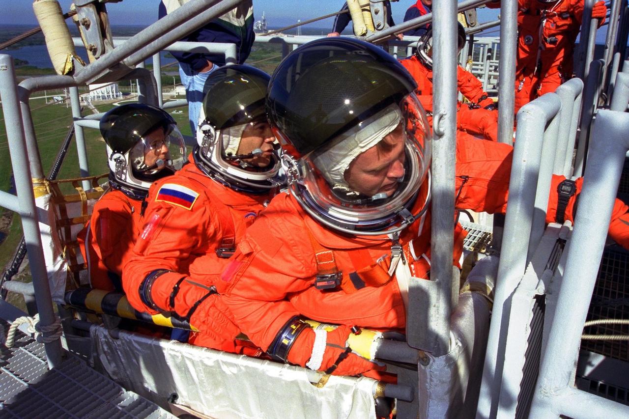 KENNEDY SPACE CENTER,  Fla. -- Standing in a slidewire basket at KSC’s Launch Pad 39A are, left to right, STS-89 Mission Specialists Bonnie Dunbar, Ph.D., Salizhan Sharipov of the Russian Space Agency, and Andrew Thomas, Ph.D. The seven astronauts assigned to the eighth Shuttle-Mir docking flight are completing Terminal Countdown Demonstration Test (TCDT) activities. A dress rehearsal for launch, the TCDT includes emergency egress training at the launch pad and culminates with a simulated countdown. STS-89 Mission Specialist Dr. Thomas will transfer to the Russian Space Station Mir and succeed David Wolf, M.D., who will return to Earth aboard Endeavour. The Space Shuttle Endeavour is undergoing preparations for liftoff, scheduled for Jan. 22. Dr. Thomas will live and work on Mir until June