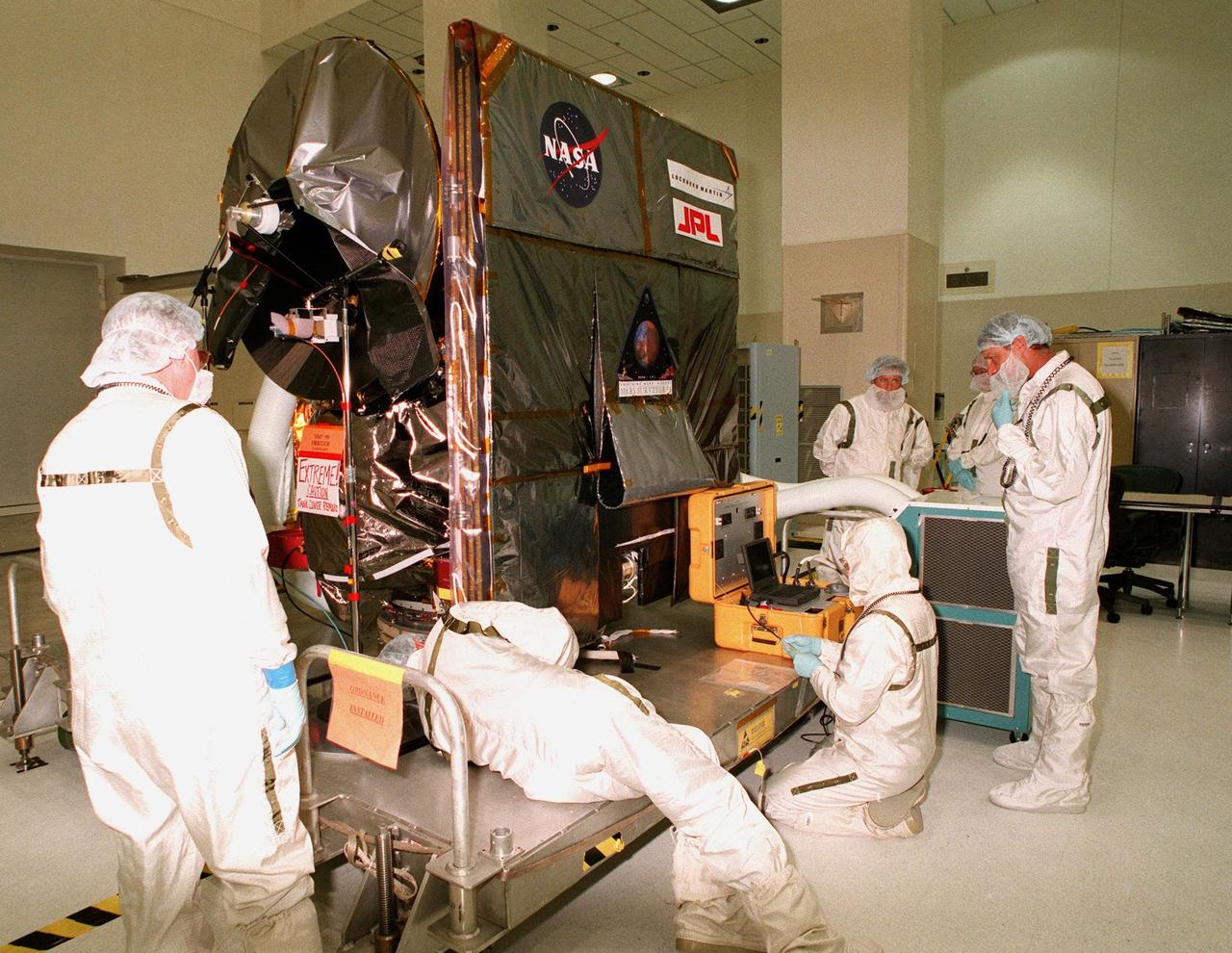 KENNEDY SPACE CENTER, FLA. -- In the Spacecraft Assembly and Encapsulation Facility-2 (SAEF-2), a technician works on the Mars Climate Orbiter which is scheduled to launch on Dec. 10, 1998, aboard a Boeing Delta II rocket. The Mars Climate Orbiter is heading for Mars where it will primarily support its companion Mars Polar Lander spacecraft, planned for launch on Jan. 3, 1999. After that, the Mars Climate Orbiter's instruments will monitor the Martian atmosphere and image the planet's surface on a daily basis for one Martian year (two Earth years). It will observe the appearance and movement of atmospheric dust and water vapor, as well as characterize seasonal changes on the surface. The detailed images of the surface features will provide important clues to the planet's early climate history and give scientists more information about possible liquid water reserves beneath the surface