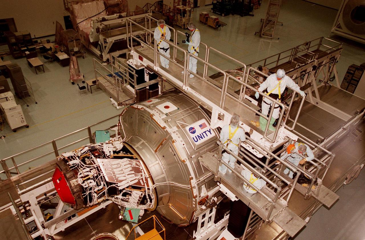 In the Space Station Processing Facility, workers look over the Unity connecting module, part of the International Space Station, after attaching the nameplate. Unity was expected to be transported to Launch Pad 39A on Oct. 26 for launch aboard Space Shuttle Endeavour on Mission STS-88 in December. The Unity is a connecting passageway to the living and working areas of ISS. While on orbit, the flight crew will deploy Unity from the payload bay and attach Unity to the Russian-built Zarya control module which will be in orbit at that time