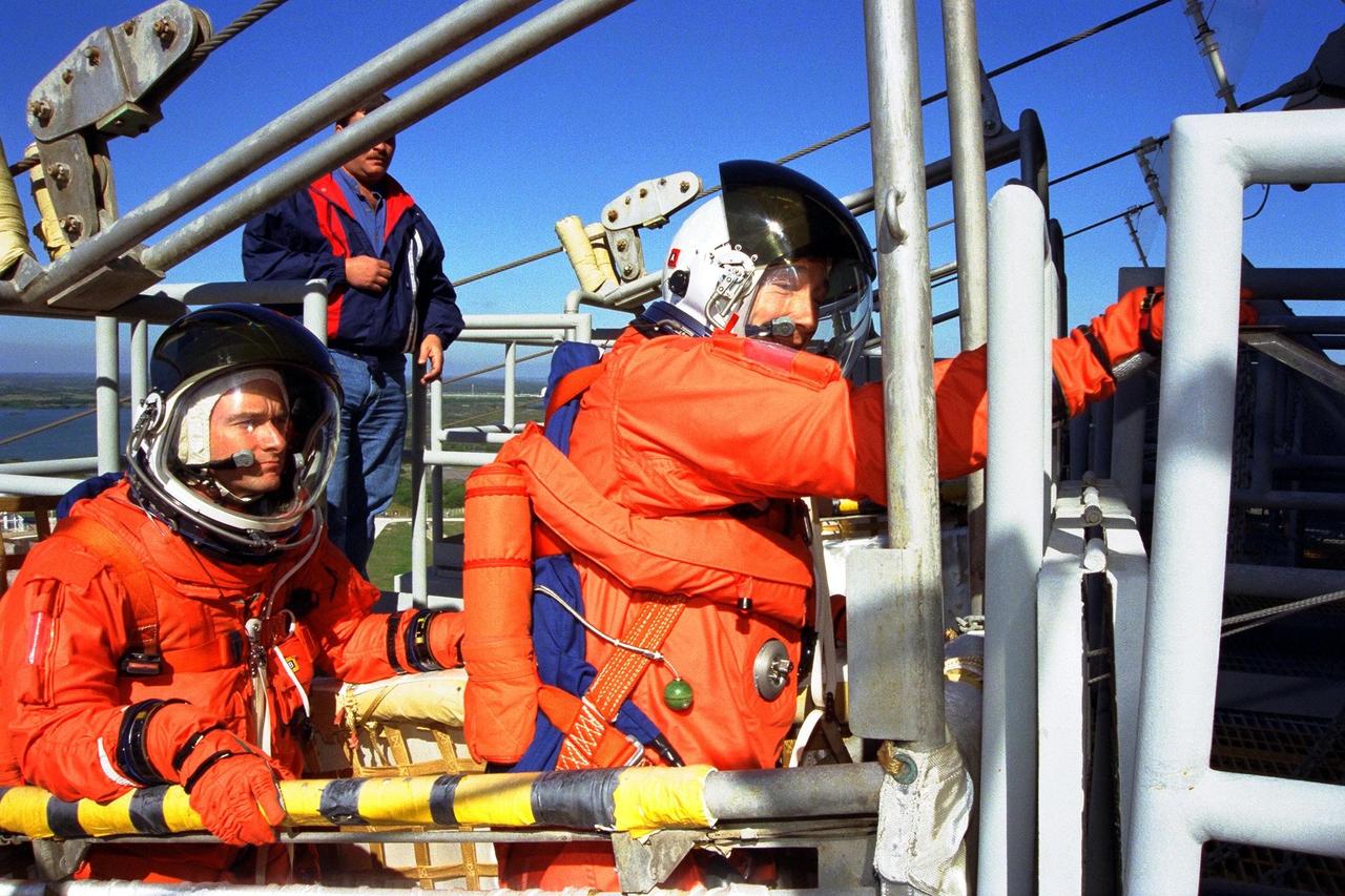 KENNEDY SPACE CENTER,  Fla. -- Standing in a slidewire basket at KSC’s Launch Pad 39A are, left to right, STS-89 Pilot Joe Edwards Jr. and Commander Terrence Wilcutt. The seven astronauts assigned to the eighth Shuttle-Mir docking flight are completing Terminal Countdown Demonstration Test (TCDT) activities. A dress rehearsal for launch, the TCDT includes emergency egress training at the launch pad and culminates with a simulated countdown. STS-89 Mission Specialist Andrew Thomas, Ph.D., will transfer to the Russian Space Station Mir and succeed David Wolf, M.D., who will return to Earth aboard Endeavour. The Space Shuttle Endeavour is undergoing preparations for liftoff, scheduled for Jan. 22. Dr. Thomas will live and work on Mir until June