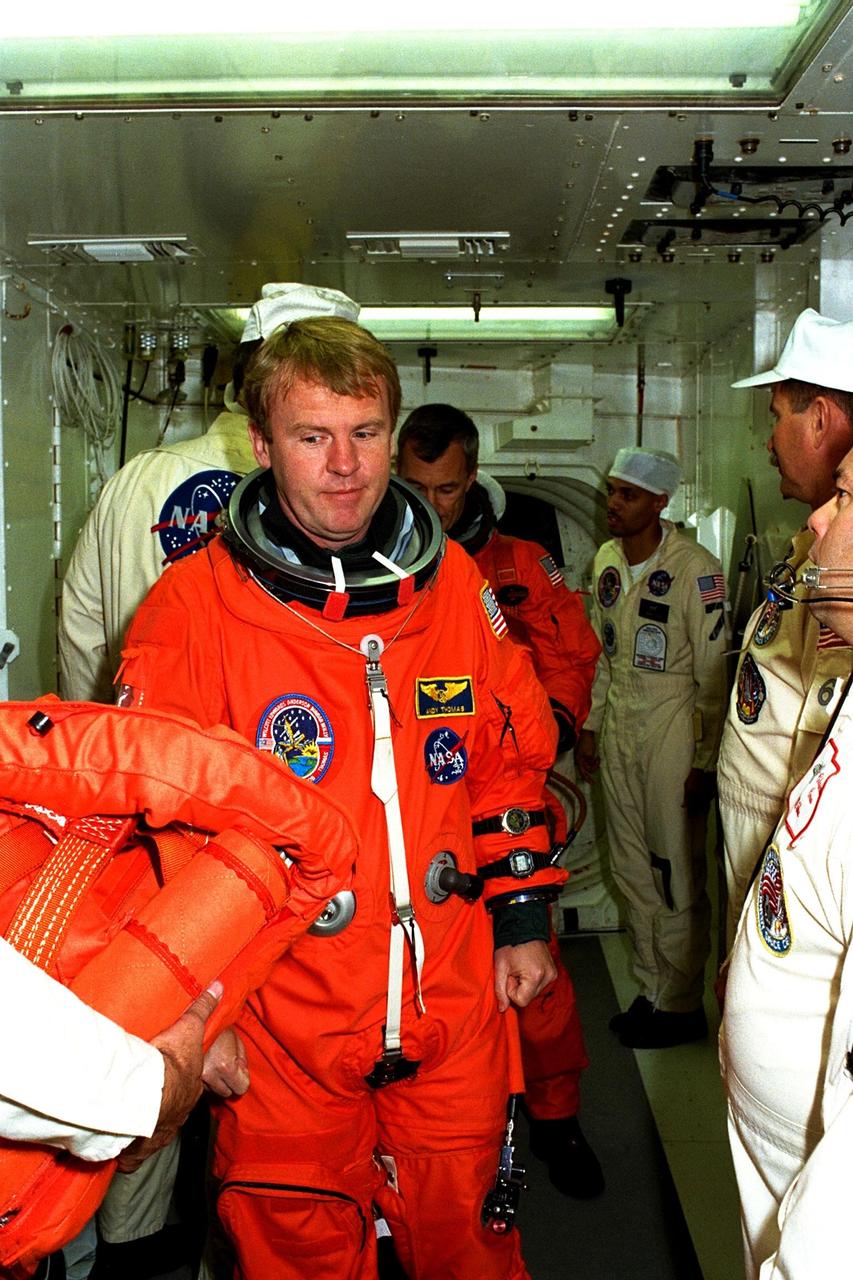 STS-89 Mission Specialist Andrew Thomas, Ph.D., prepares to enter the Space Shuttle Endeavour at Launch Pad 39A with help from white room closeout crew members as part of Terminal Countdown Demonstration Test (TCDT) activities. The TCDT is held at KSC prior to each Space Shuttle flight to provide crews with an opportunity to participate in simulated countdown activities. The STS-89 mission will be the eighth docking of the Space Shuttle with the Russian Space Station Mir. After docking, Dr. Thomas will transfer to the space station, succeeding David Wolf, M.D., who will return to Earth aboard Endeavour. Dr. Thomas will live and work on Mir until June. STS-89 is scheduled for a Jan. 22 liftoff at 9:48 p.m
