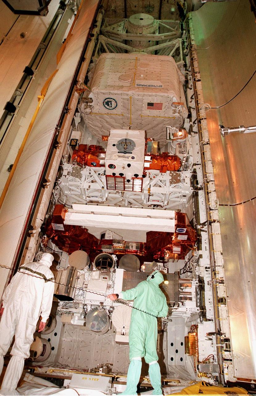 KENNEDY SPACE CENTER, FLA. -- On Launch Complex 39B, KSC workers check the payloads for mission STS-95 which were loaded into the orbiter Discovery payload bay before launch. The mission includes the SPACEHAB single module (seen at the top of the bay) with experiments on space flight and the aging process, the International Extreme Ultraviolet Hitchhiker (IEH-3), the Hubble Space Telescope Orbital Systems Test Platform, and the Spartan solar-observing deployable spacecraft. STS-95 is expected to launch at 2 p.m. EST on Oct. 29, last 8 days, 21 hours and 49 minutes, and land at 11:49 a.m. EST on Nov. 7