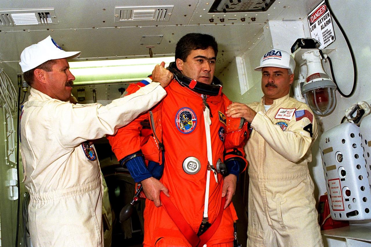 Assisted with flight gear by white room closeout crew members is STS-89 Mission Specialist Salizhan Sharipov of the Russian Space Agency as part of Terminal Countdown Demonstration Test (TCDT) activities. The TCDT is held at KSC prior to each Space Shuttle flight to provide crews with an opportunity to participate in simulated countdown activities. The STS-89 mission will be the eighth docking of the Space Shuttle with the Russian Space Station Mir. After docking, Mission Specialist Andrew Thomas, Ph.D., will transfer to the space station, succeeding David Wolf, M.D., who will return to Earth aboard Endeavour. Dr. Thomas will live and work on Mir until June. STS-89 is scheduled for a Jan. 22 liftoff at 9:48 p.m