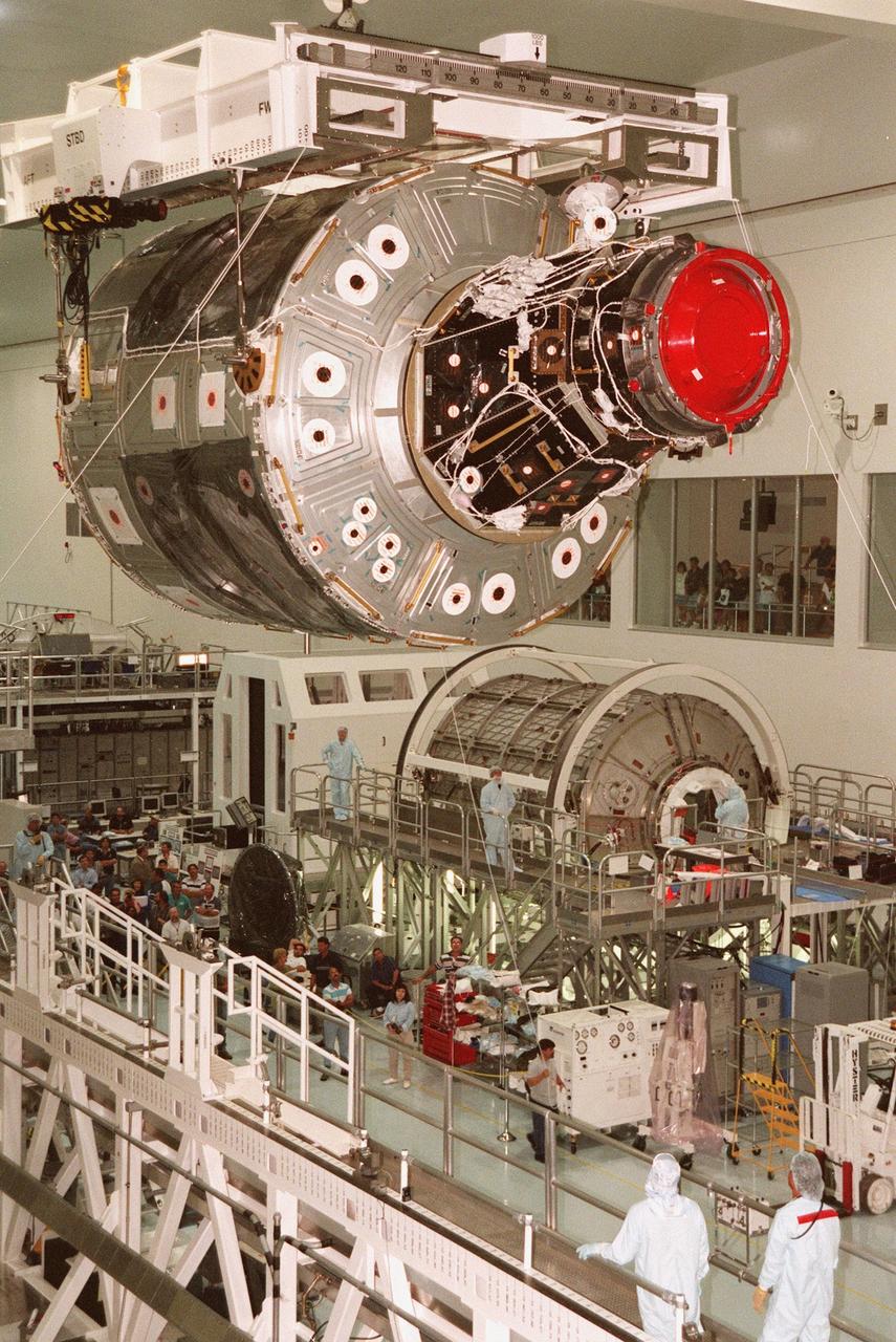 In the Space Station Processing Facility, an overhead crane moves the Unity connecting module to the payload canister for transfer to the launch pad. Part of the International Space Station (ISS), Unity is scheduled for launch aboard Space Shuttle Endeavour on Mission STS-88 in December. The Unity is a connecting passageway to the living and working areas of ISS. While on orbit, the flight crew will deploy Unity from the payload bay and attach Unity to the Russian-built Zarya control module which will be in orbit at that time