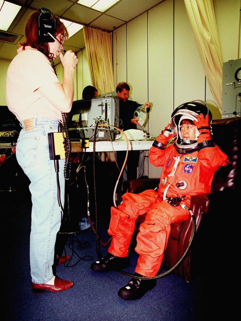In the Operations and Checkout Building, STS-95 Payload Specialist Chiaki Mukai, with the National Space Development Agency of Japan (NASDA), gets help with her suit from suit technician Monica Golden. The STS-95 crew were conducting flight crew equipment fit checks prior to launch on Oct. 29. STS-95 is expected to launch at 2 p.m. EST on Oct. 29, last 8 days, 21 hours and 49 minutes, and land at 11:49 a.m. EST on Nov. 7