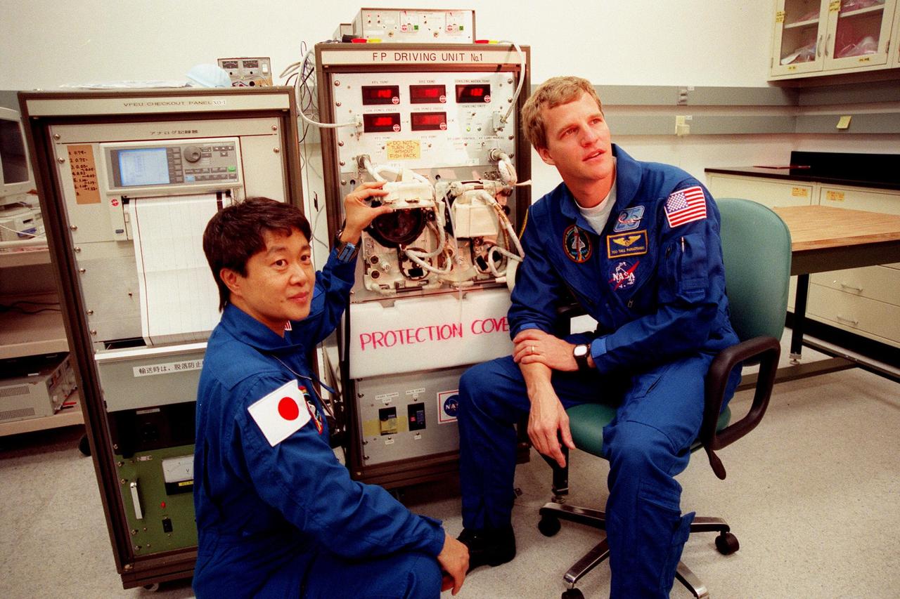 STS-95 Payload Specialist Chiaki Mukai (left), with the National Space Development Agency of Japan (NASDA), lifts the cover on a container in the Vestibular Function Experiment Unit holding one of the two toadfish that are the subjects of an experiment. Mission Specialist Scott E. Parazynski is helping her check experiments for mission STS-95. The fish will be electronically monitored to determine the effect of gravitational changes on the inner-ear system. Mukai and Parazynski and other crewmembers were making final preparations for launch, targeted for liftoff at 2 p.m. on Oct. 29. The STS-95 crew also includes Mission Commander Curtis L. Brown Jr., Pilot Steven W. Lindsey, Mission Specialist Stephen K. Robinson, Payload Specialist John H. Glenn Jr., senator from Ohio, and Mission Specialist Pedro Duque, with the European Space Agency (ESA). The mission is expected to last 8 days, 21 hours and 49 minutes, returning to KSC at 11:49 a.m. EST on Nov. 7