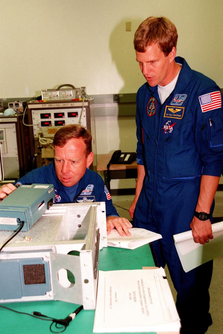 STS-95 Pilot Steven W. Lindsey and Mission Specialist Scott E. Parazynski look at equipment being used in an experiment with toadfish on the mission. The fish will be electronically monitored to determine the effect of gravitational changes on the inner-ear system. Lindsey and Parazynski and other crewmembers were making final preparations for launch, targeted for liftoff at 2 p.m. on Oct. 29. The STS-95 crew also includes Mission Commander Curtis L. Brown Jr., Mission Specialists Stephen K. Robinson and Pedro Duque, with the European Space Agency (ESA), Payload Specialists John H. Glenn Jr., senator from Ohio, and Chiaki Mukai, with the National Space Development Agency of Japan (NASDA), ). The mission is expected to last 8 days, 21 hours and 49 minutes, returning to KSC at 11:49 a.m. EST on Nov. 7