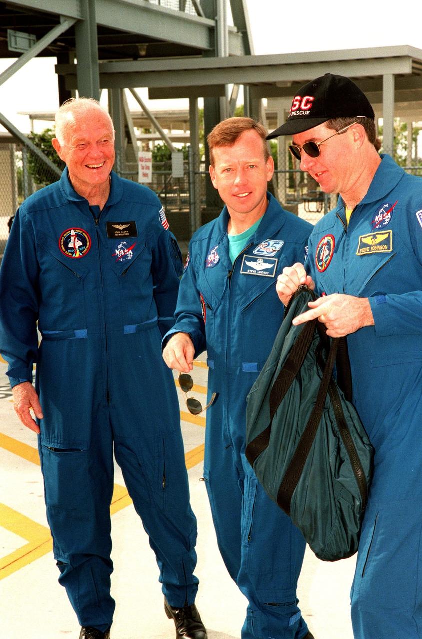 STS-95 Payload Specialist John H. Glenn Jr., senator from Ohio, smiles at his fellow crew members (middle) Pilot Steven W. Lindsey and (right) Mission Specialist Stephen K. Robinson while visiting Launch Pad 39B. The crew were making final preparations for launch, targeted for liftoff at 2 p.m. on Oct. 29. The other crew members (not shown) are Mission Specialist Scott E. Parazynski, Payload Specialist Chiaki Mukai, with the National Space Development Agency of Japan (NASDA), Mission Commander Curtis L. Brown Jr., and Mission Specialist Pedro Duque of Spain, with the European Space Agency (ESA). The STS-95 mission is expected to last 8 days, 21 hours and 49 minutes, returning to KSC at 11:49 a.m. EST on Nov. 7