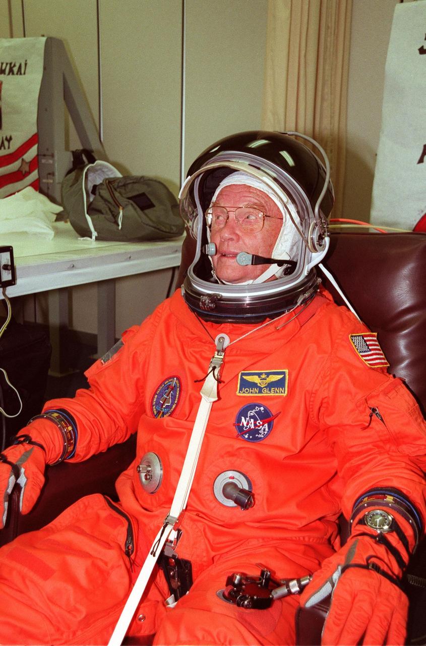 STS-95 Payload Specialist John H. Glenn Jr., senator from Ohio, smiles as he dons his flight suit in the Operations and Checkout Building. The final fitting takes place prior to the crew walkout and transport to Launch Pad 39B. Targeted for launch at 2 p.m. EST on Oct. 29, the mission is expected to last 8 days, 21 hours and 49 minutes, and return to KSC at 11:49 a.m. EST on Nov. 7. The STS-95 mission includes research payloads such as the Spartan solar-observing deployable spacecraft, the Hubble Space Telescope Orbital Systems Test Platform, the International Extreme Ultraviolet Hitchhiker, as well as the SPACEHAB single module with experiments on space flight and the aging process